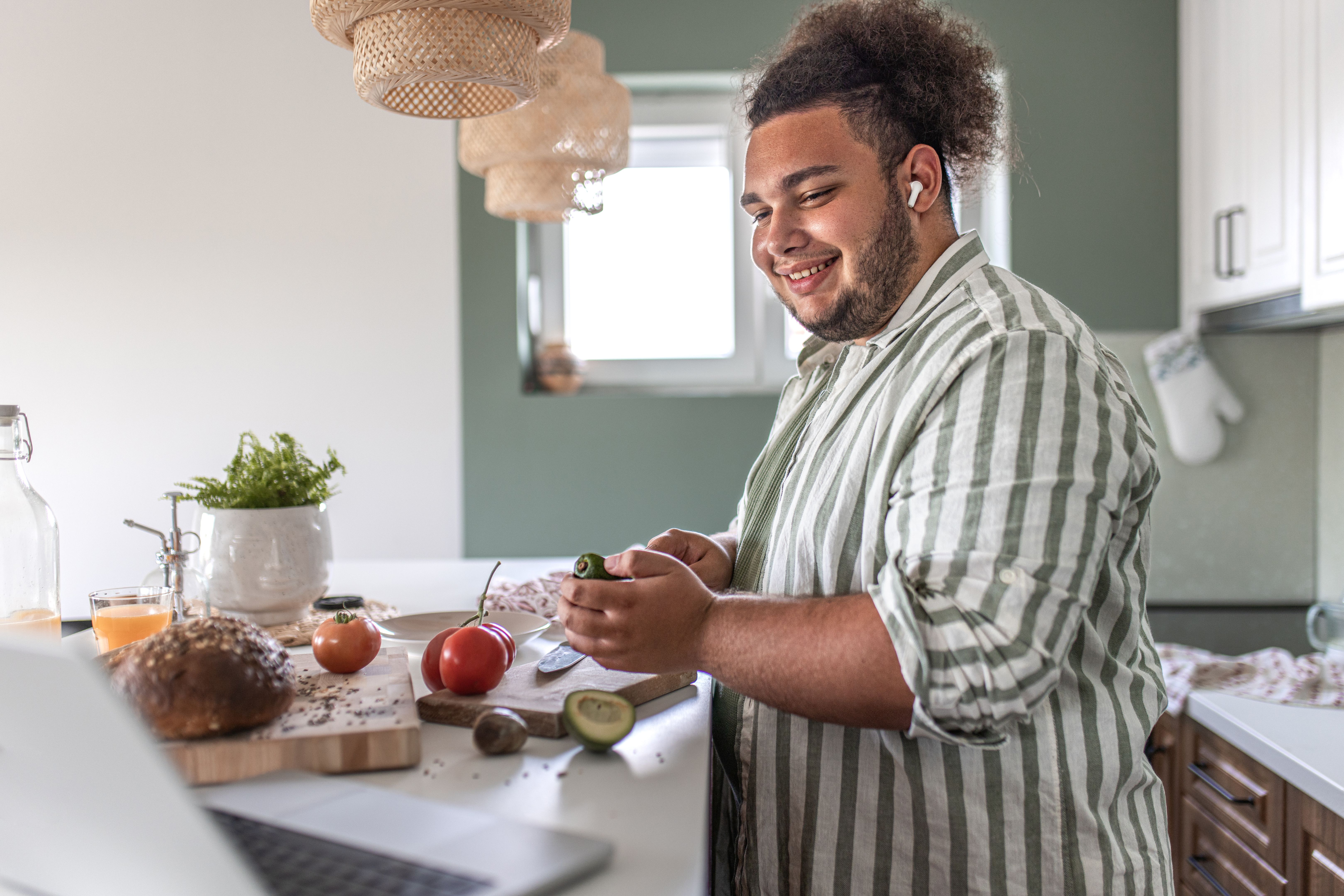 Charming young man preparing food at kitchen counter