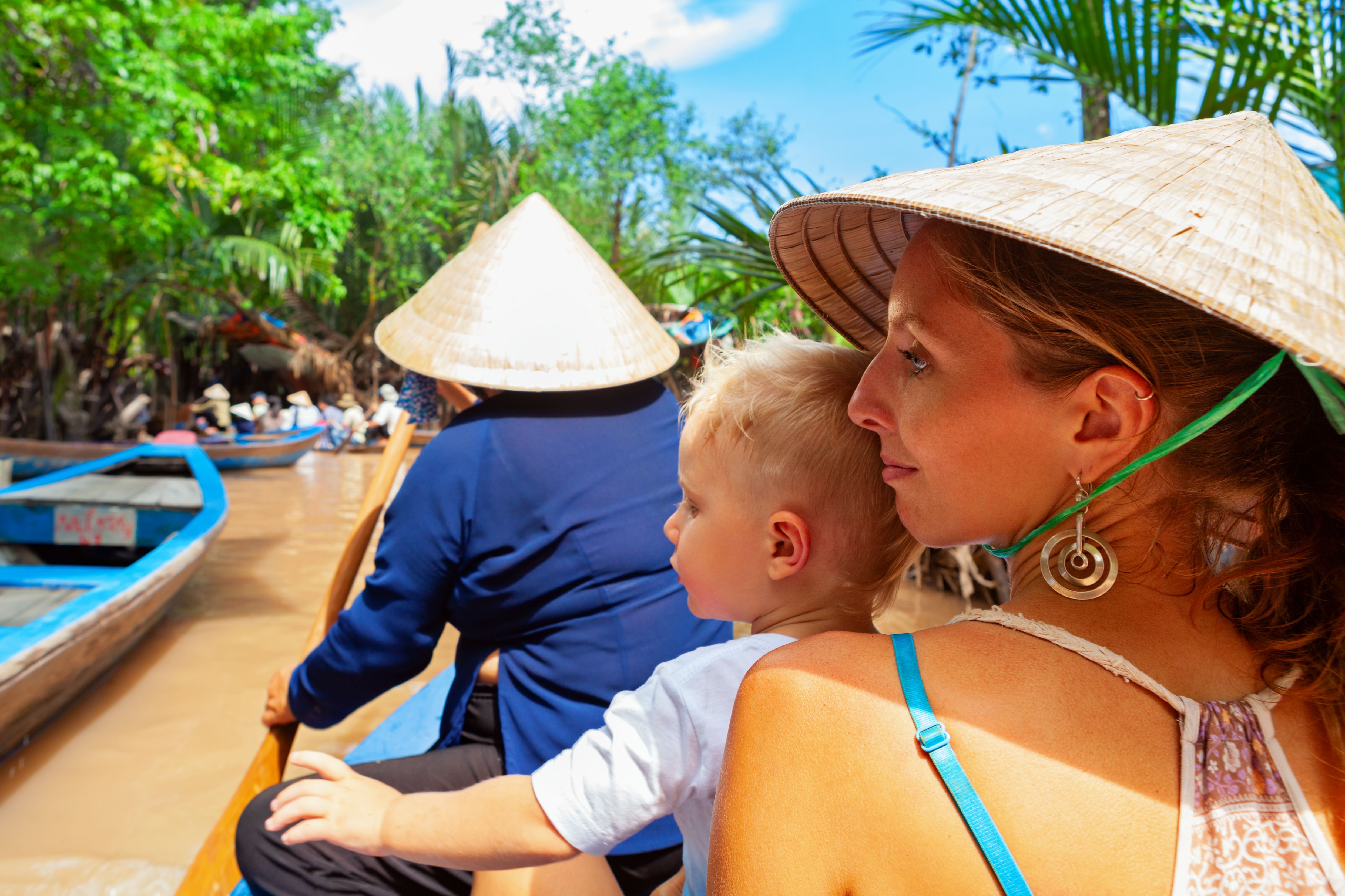 Family ride on traditional Vietnamese boat in Mekong river delta