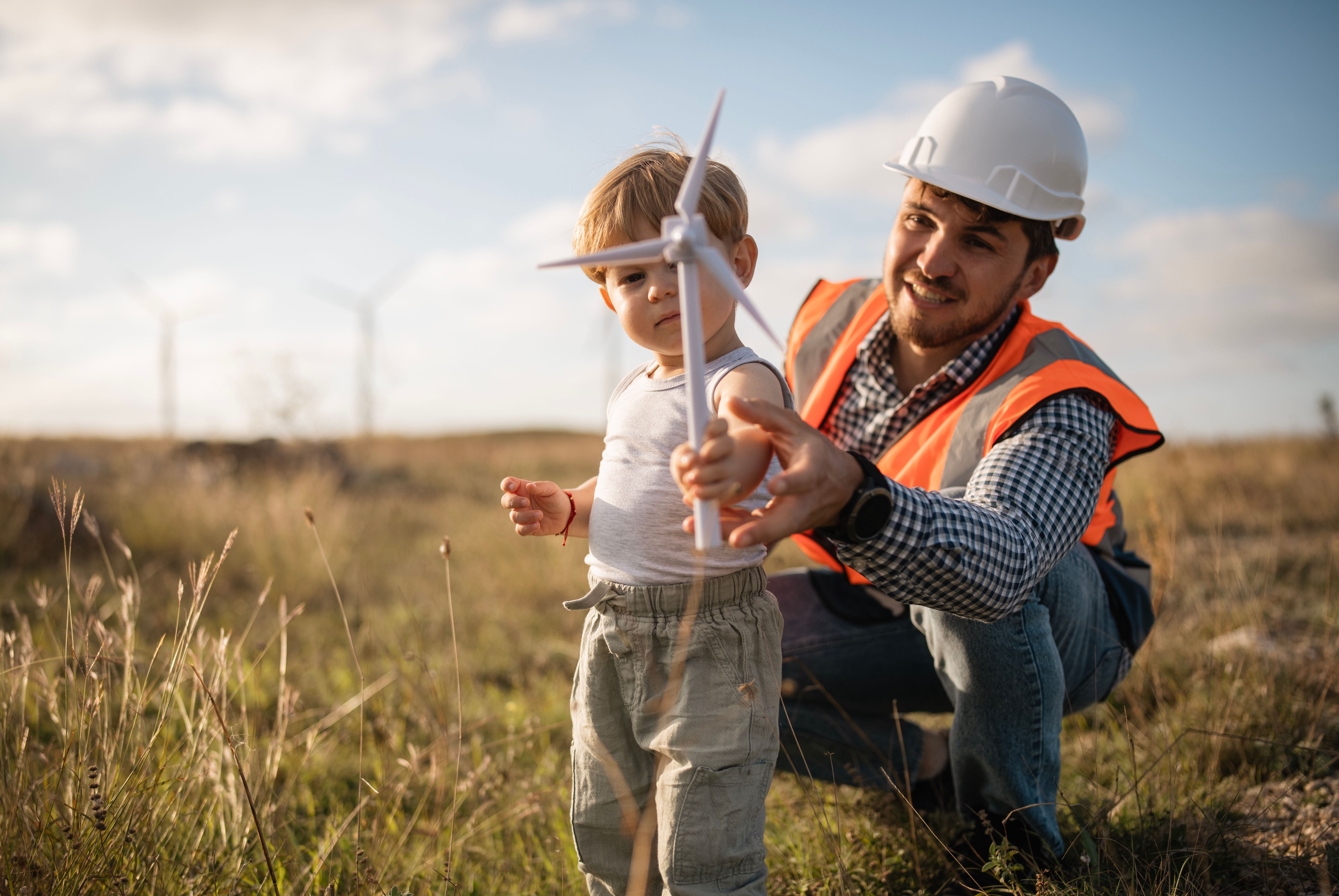 Our children are our future and the continuers of our deeds.Engineer showing his little boy his work place at the wind power station.