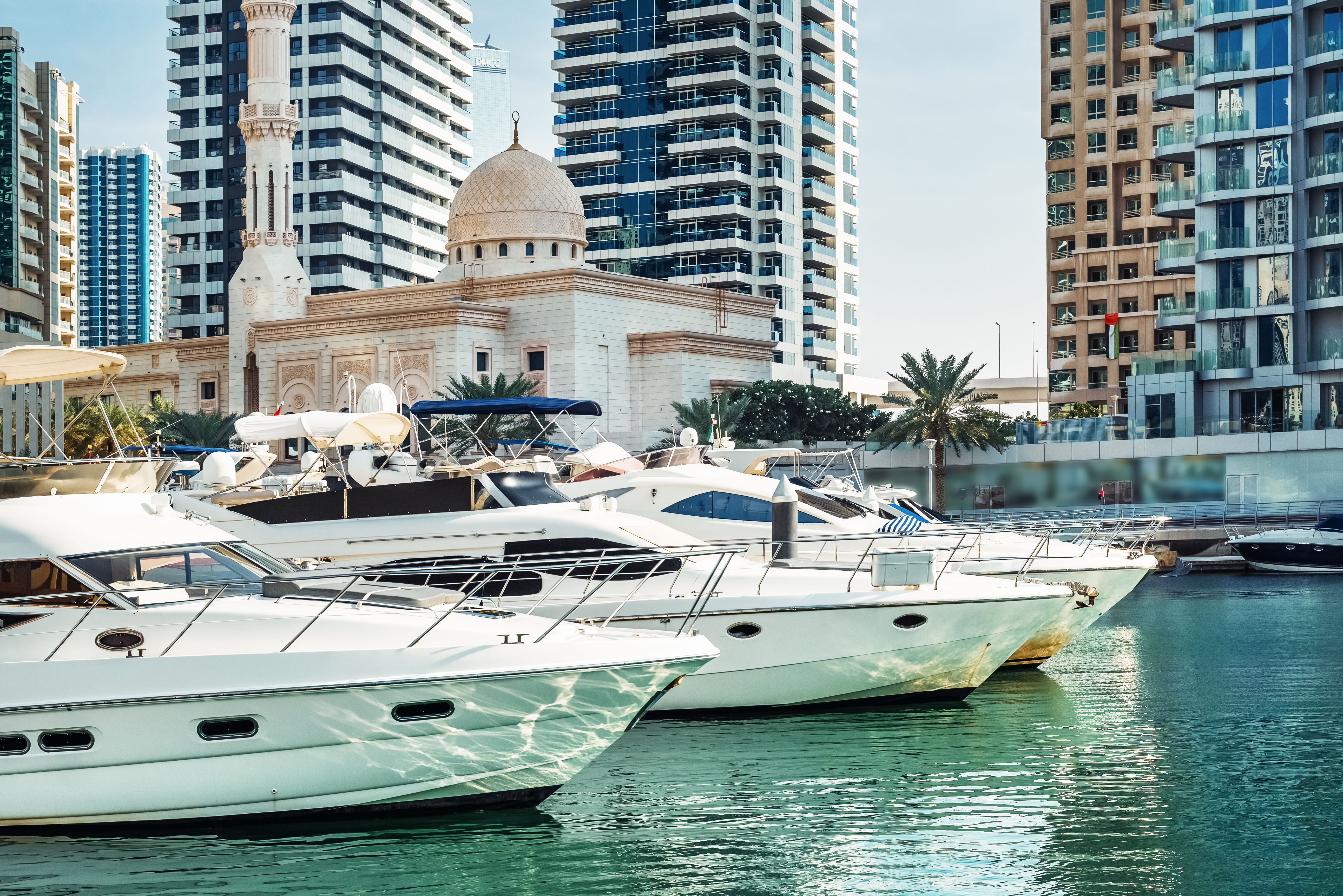Dubai. Visitors enjoy the serene waters of Dubai Marina while admiring luxurious yachts at the pier.