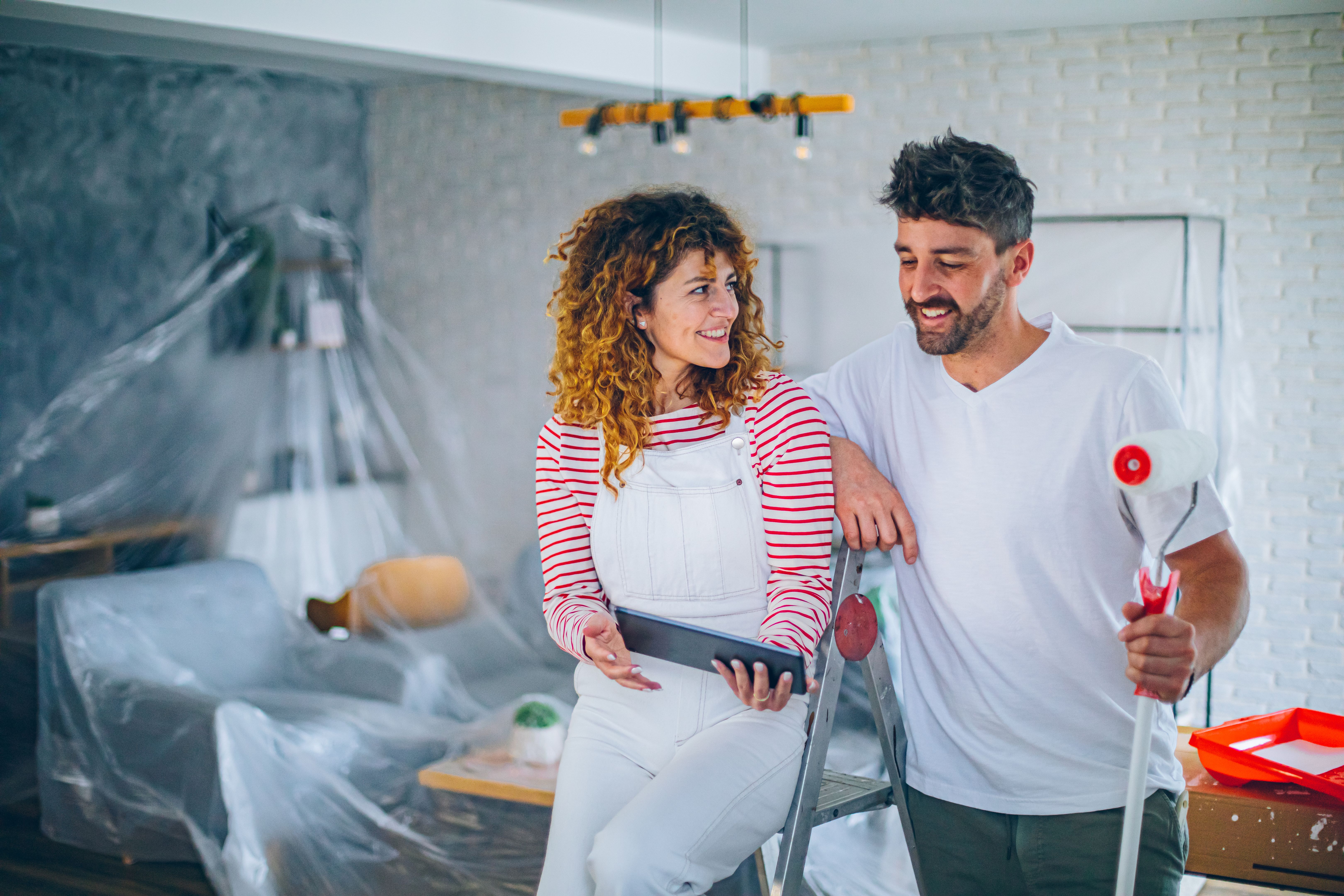 Young couple choosing paint color from samples for new home interior design