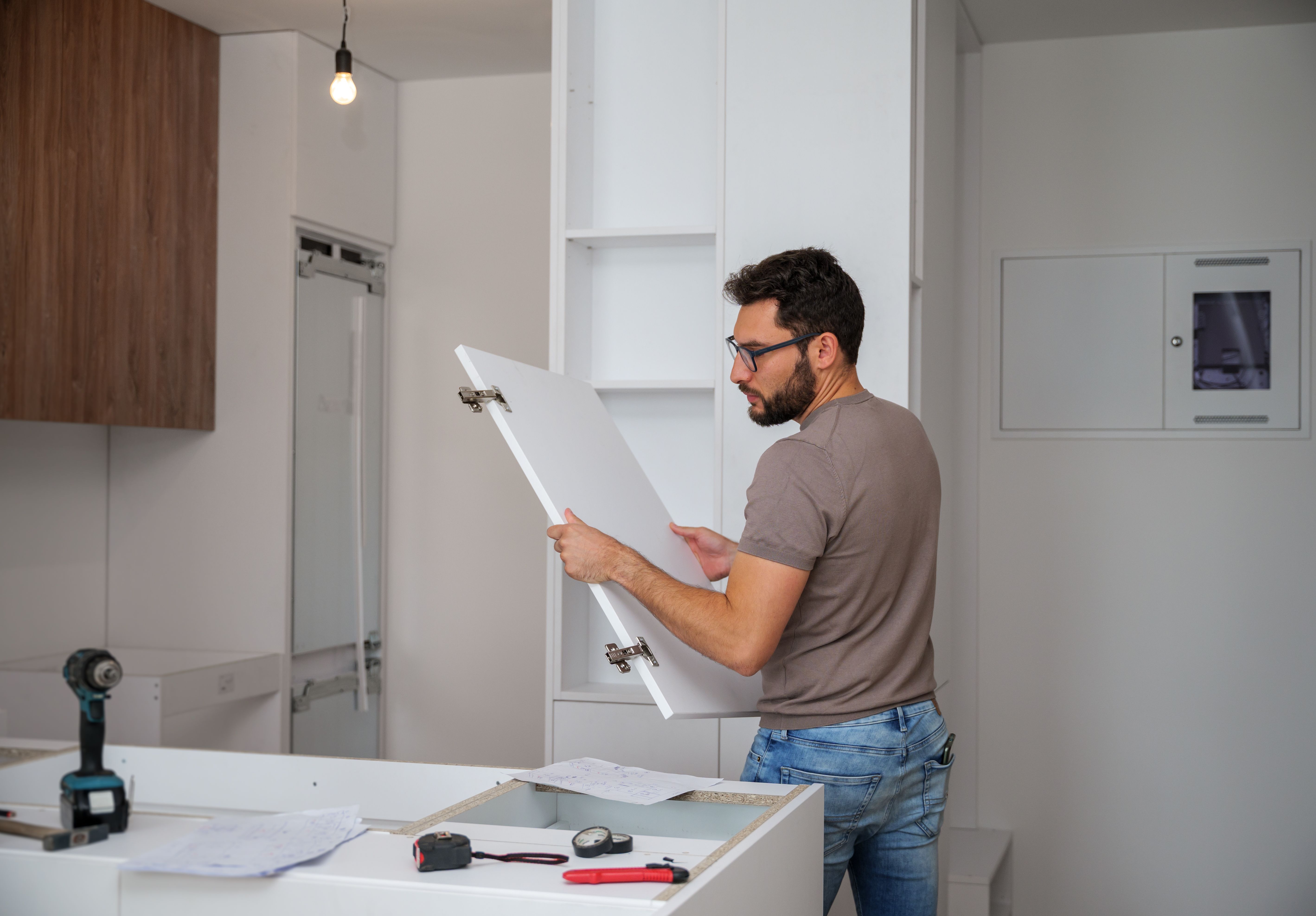 A man assembling a kitchen cabinet