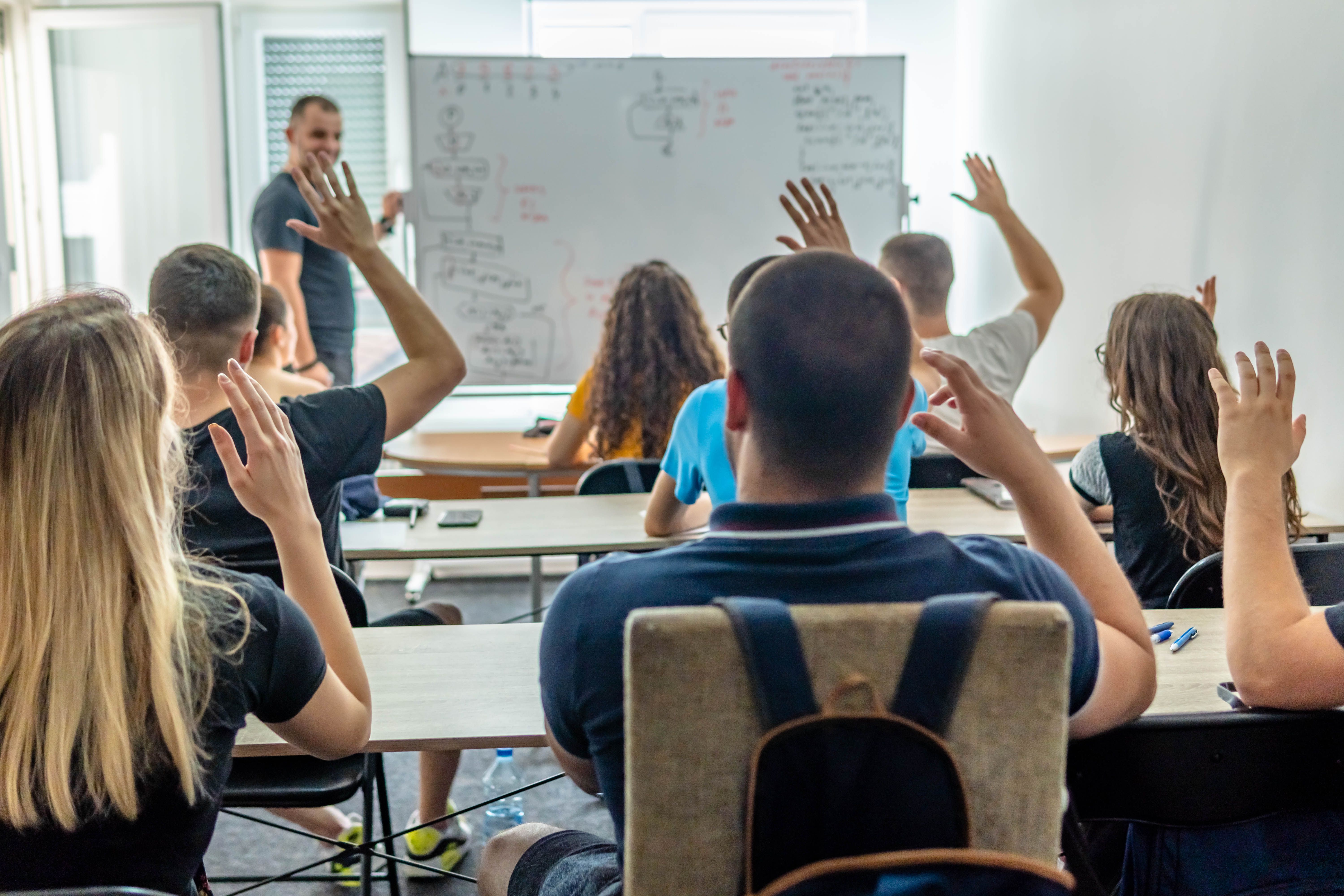 Latin American young man teaching a class to a group of college students