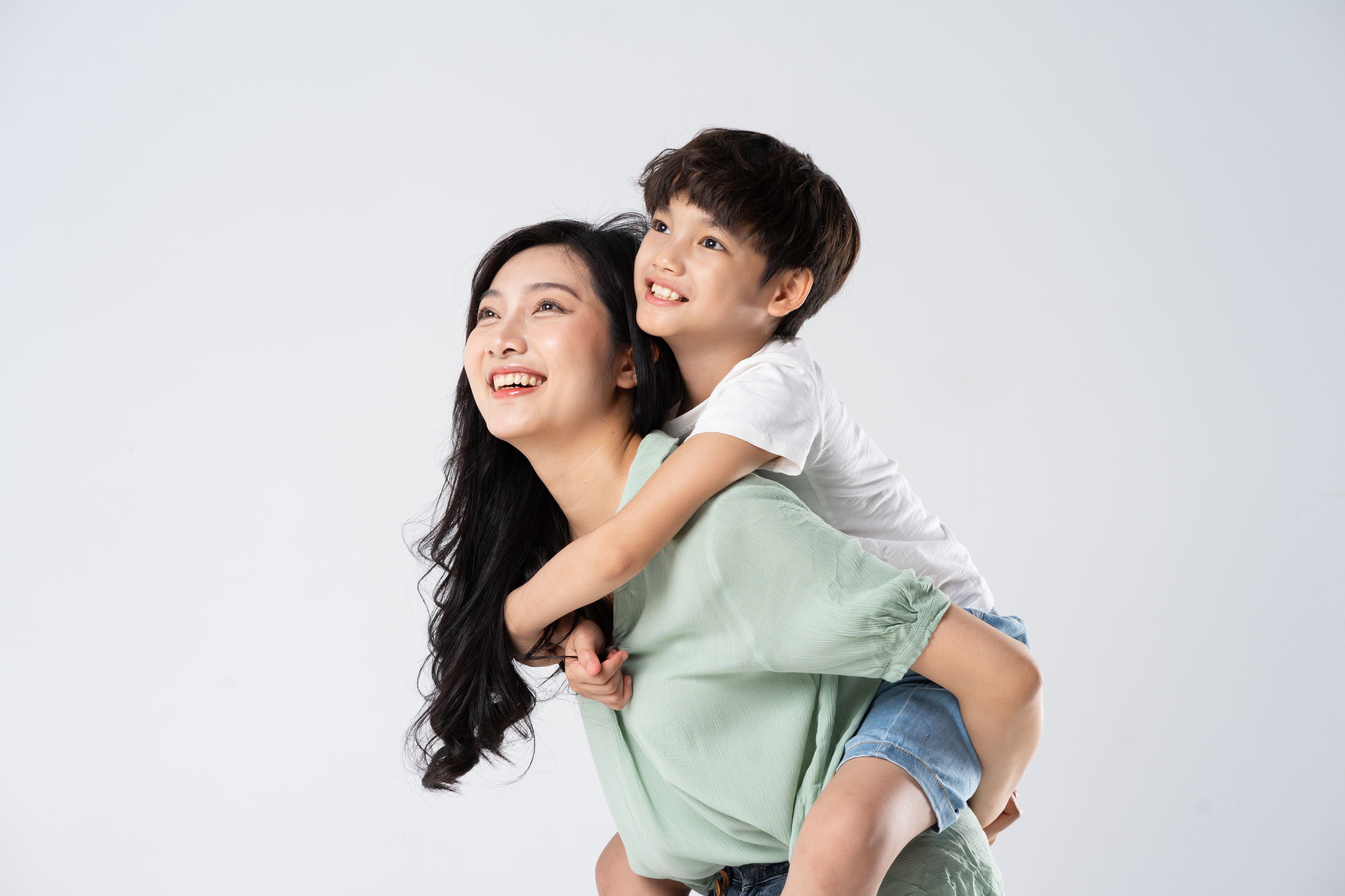 mother and son posing on a white background