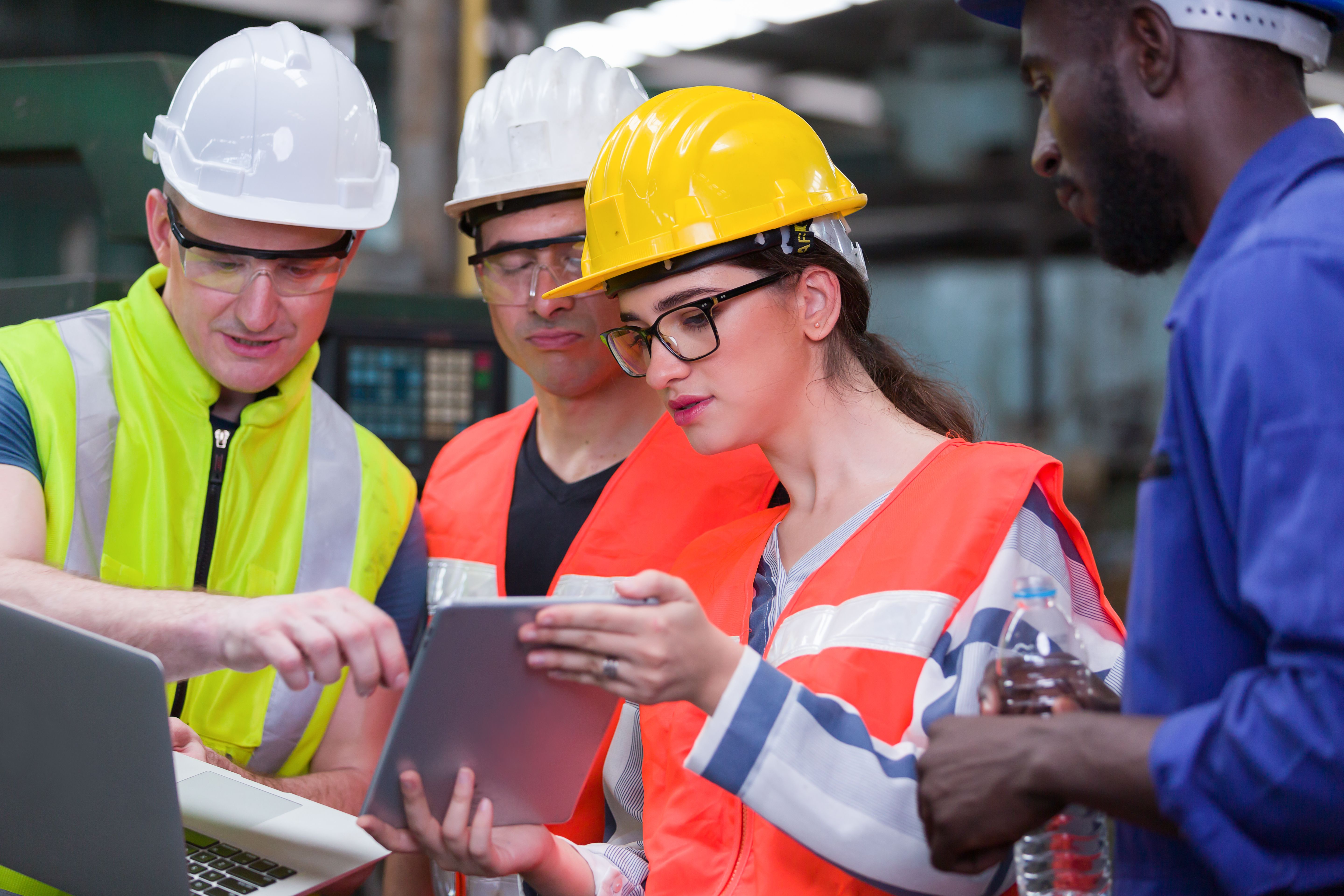 Group of factory worker working with computer laptop in factory. Male and female worker discussing and training about work at factory.