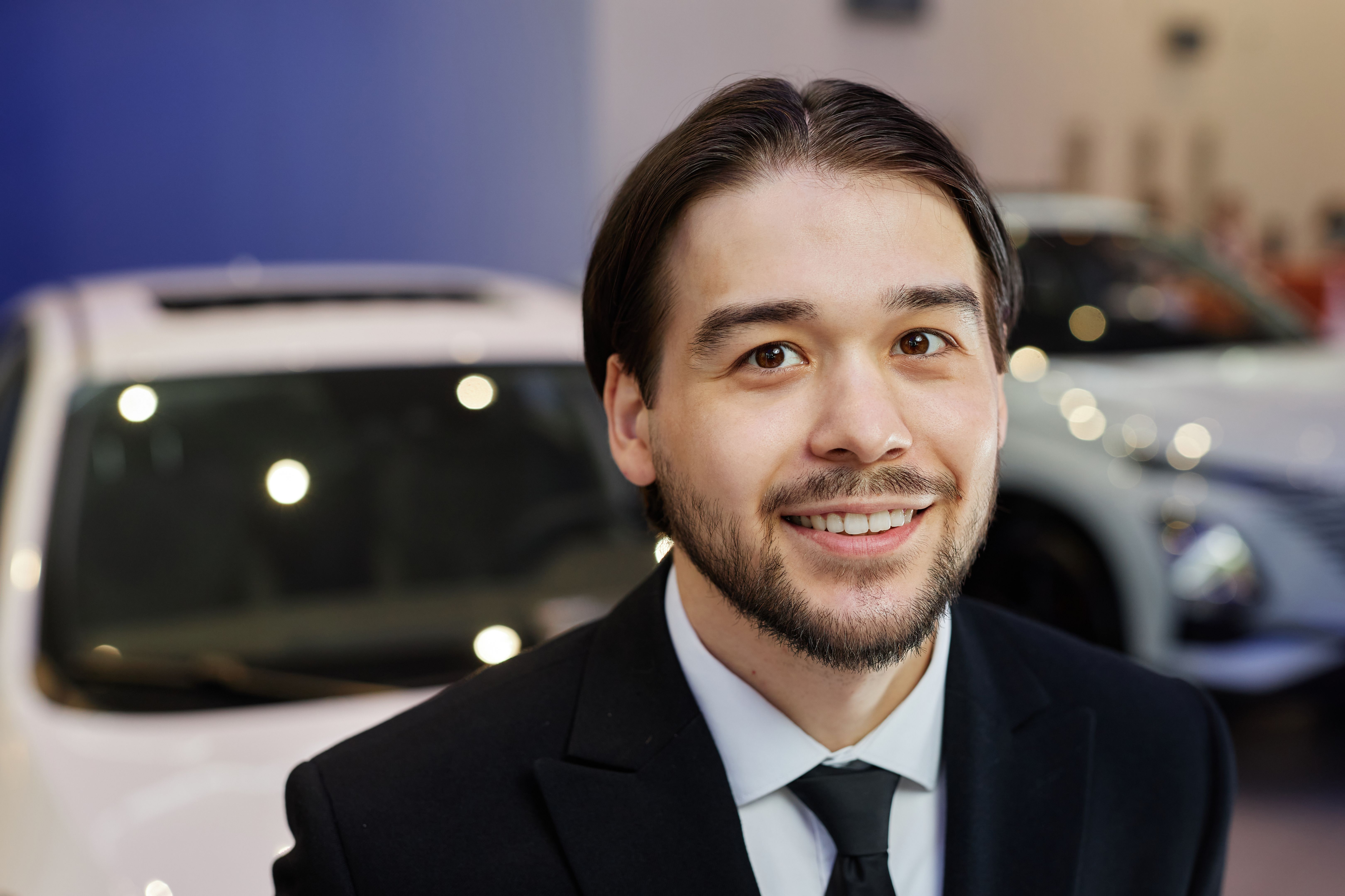 Portrait of Smiling Asian Male Auto Dealer at Car Dealership Center