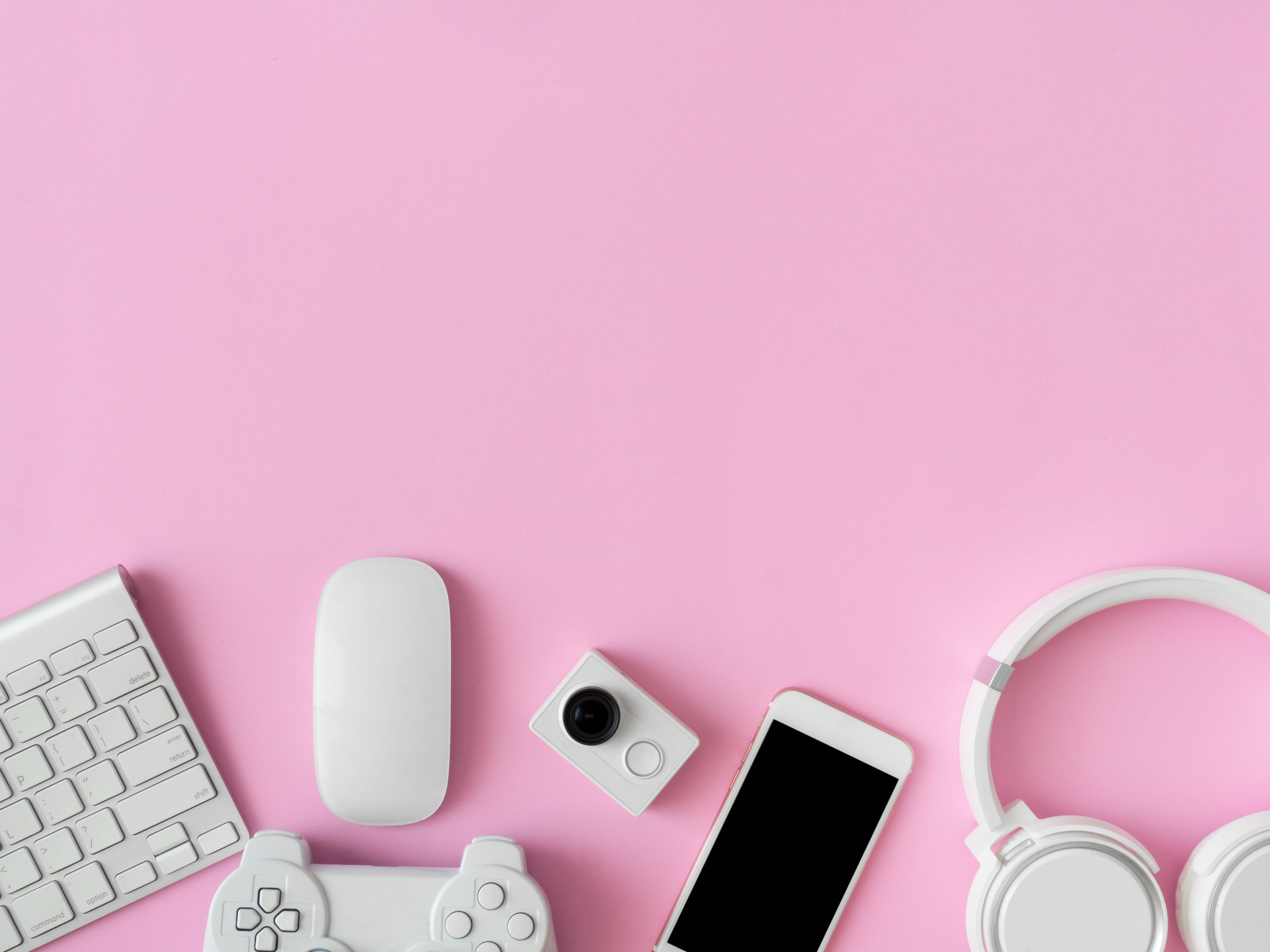 top view of office desk workspace with smartphone, notebook, graphic tablet, keyboard and mouse on pink color background, graphic designer, Creative Designer concept.