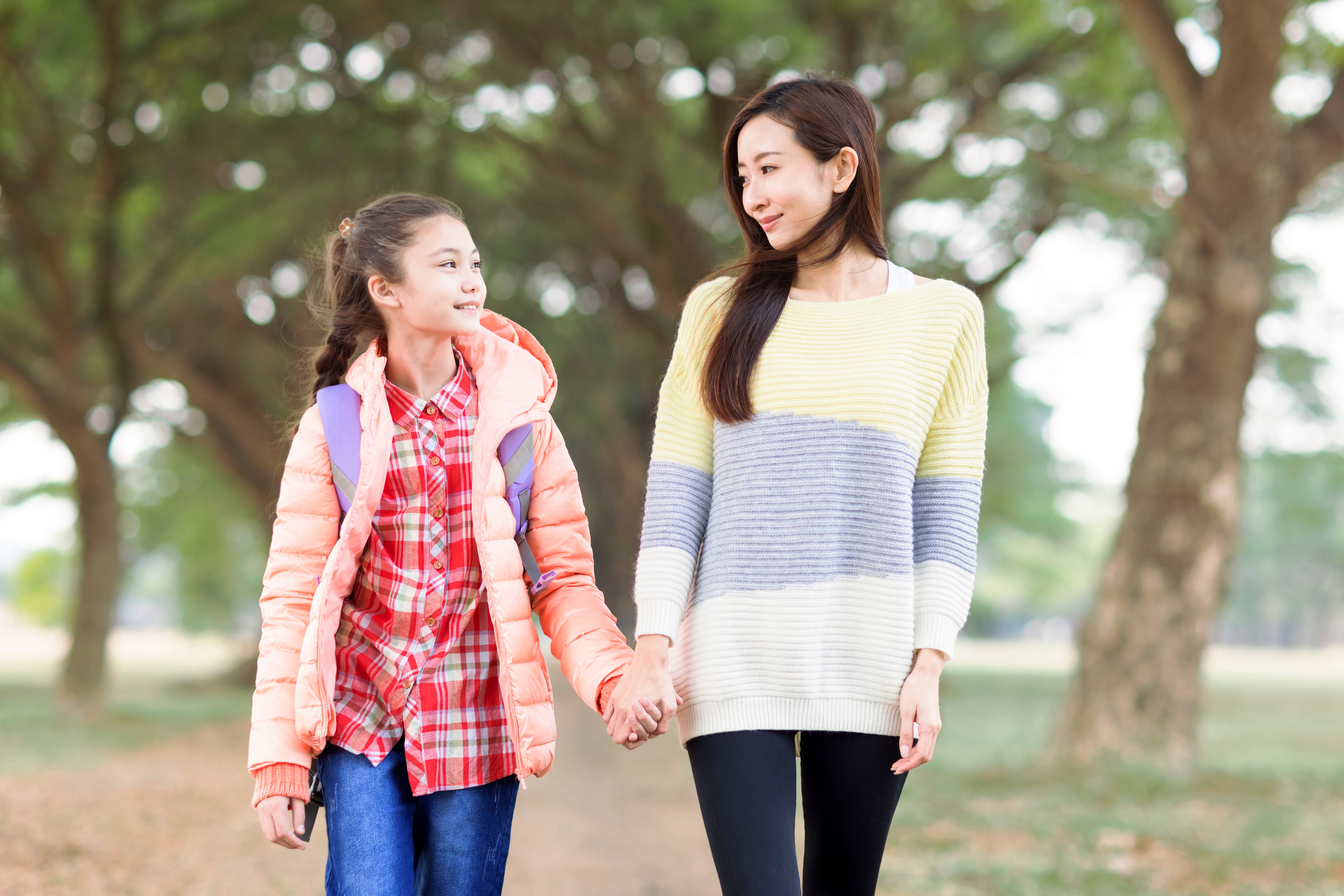 Happy girl walk with her mother to go to school