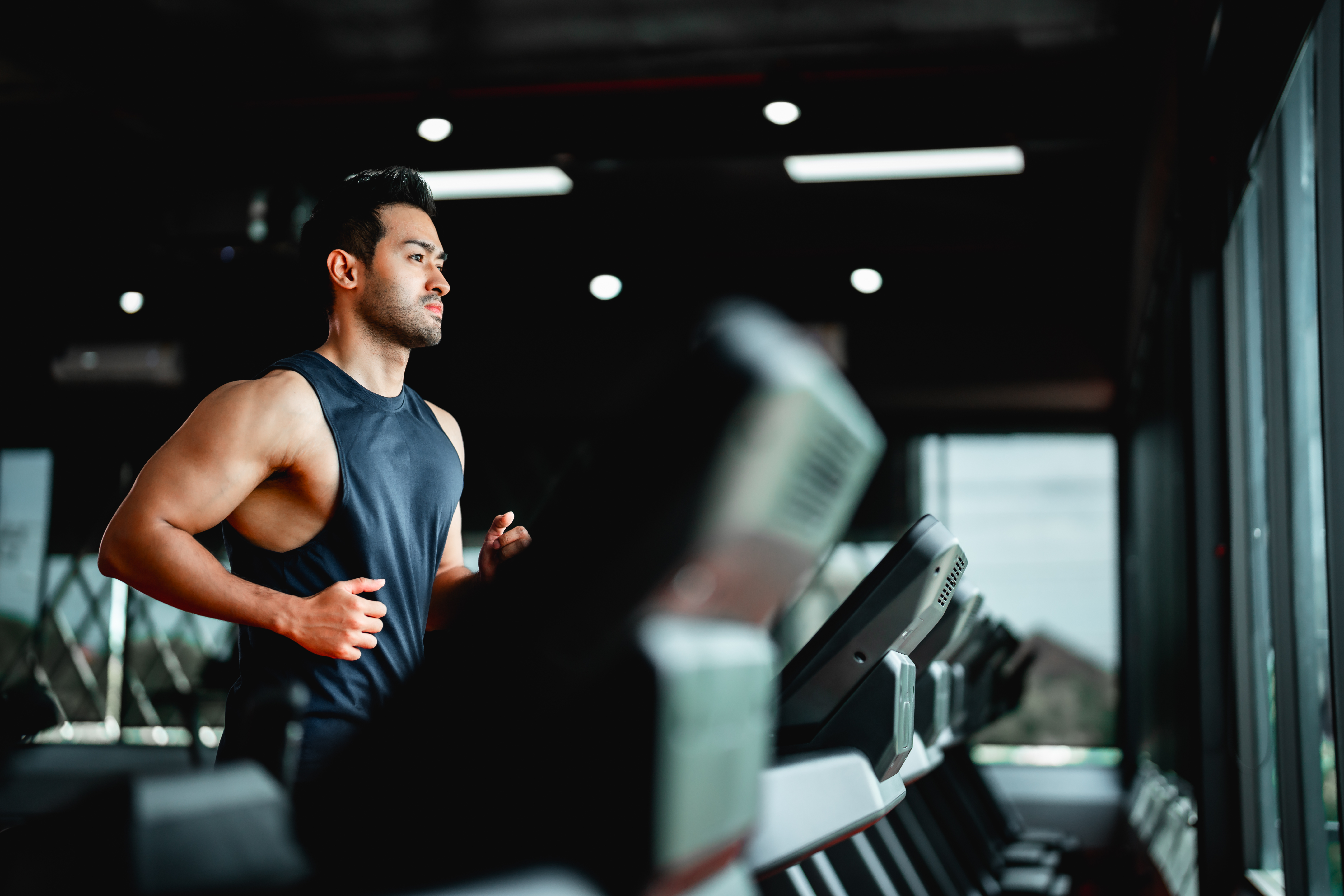 Young Asian Man Running on Treadmill - Fitness Gym Exercise