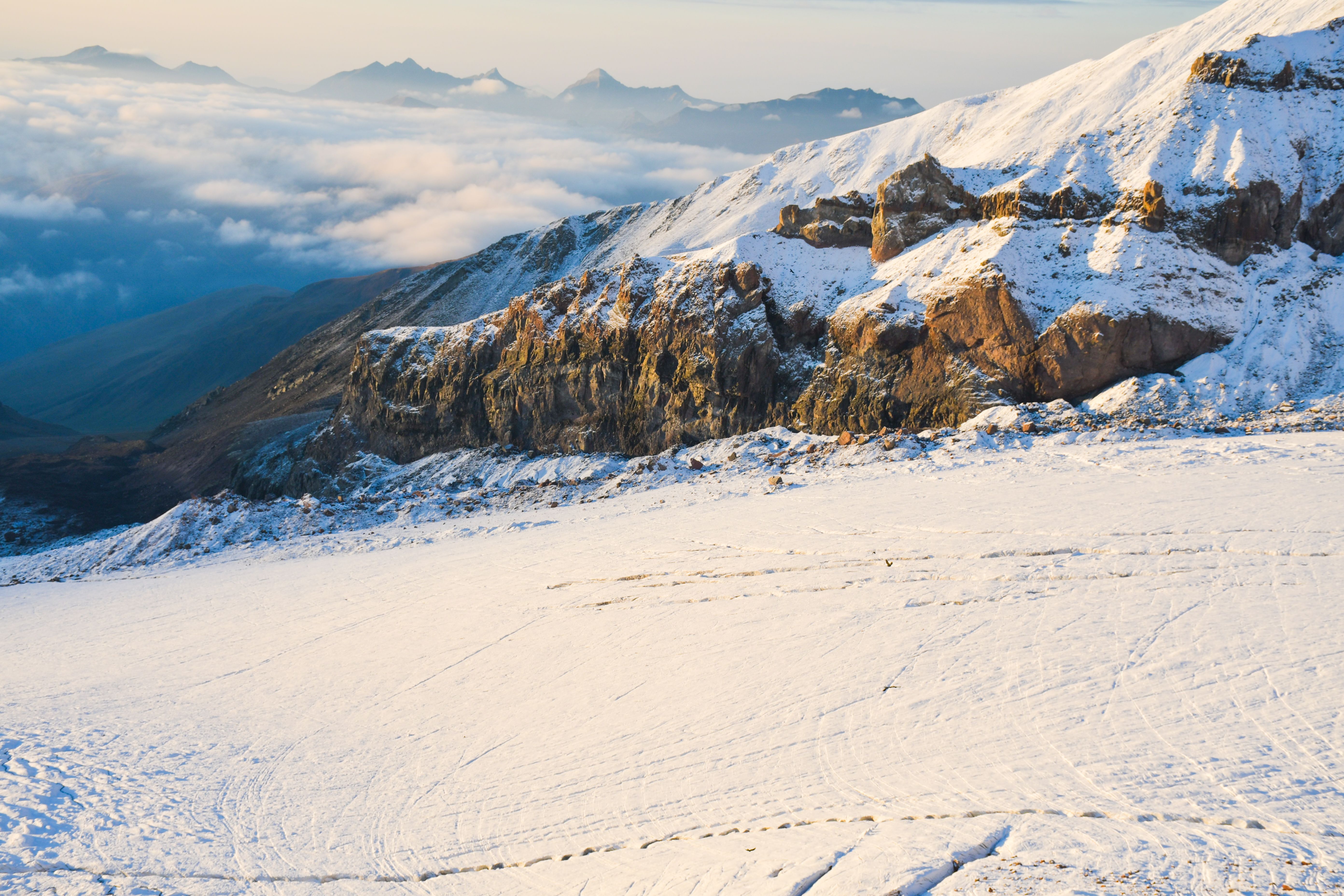 Aerial view close up Gergeti glacier tongue located on the southeastern slope of Mt. Kazbek. Kazbegi District of Georgia. Mount Kazbek climbing route. Caucasus mountain range snowy peaks