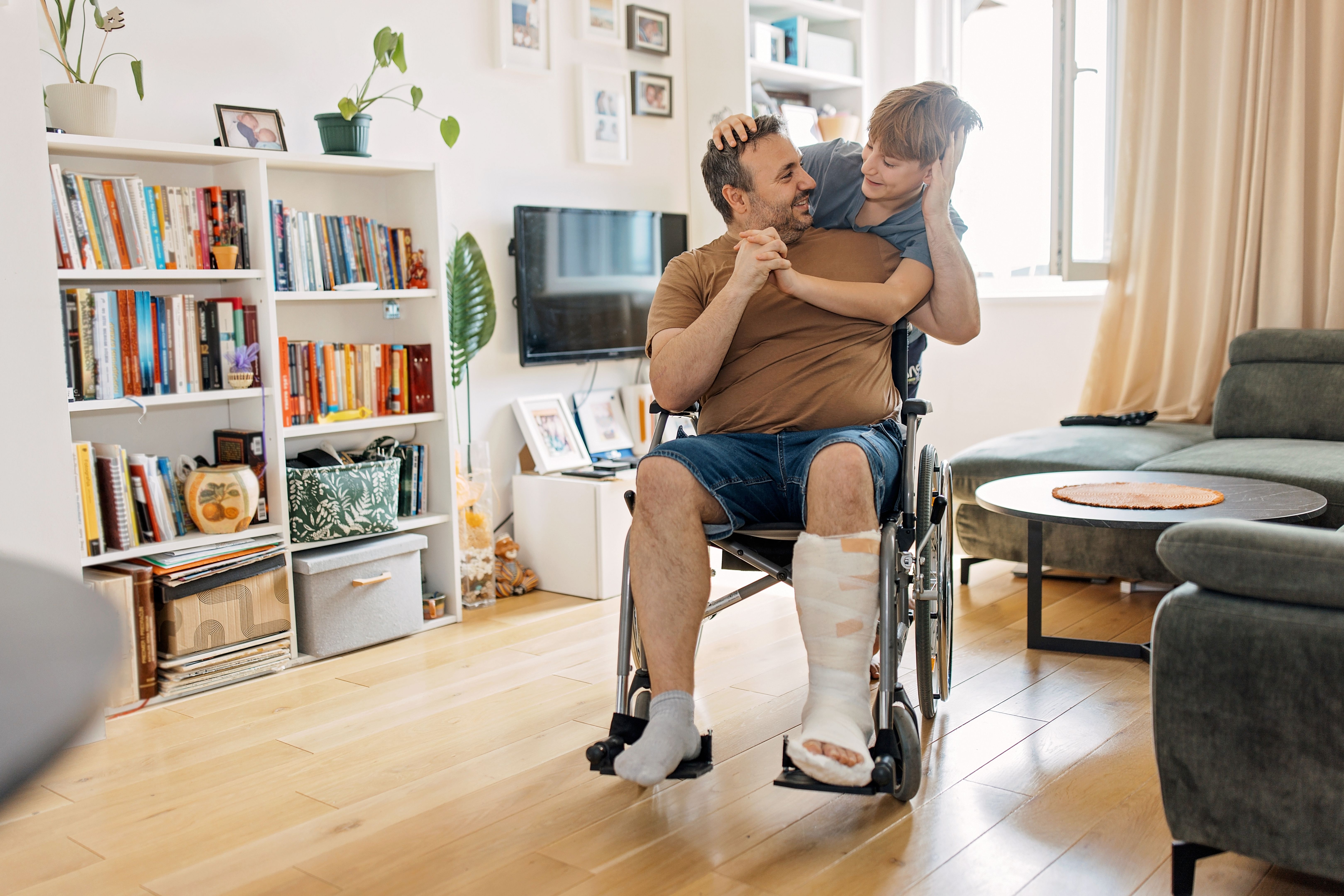 Boy showing affection to disabled dad