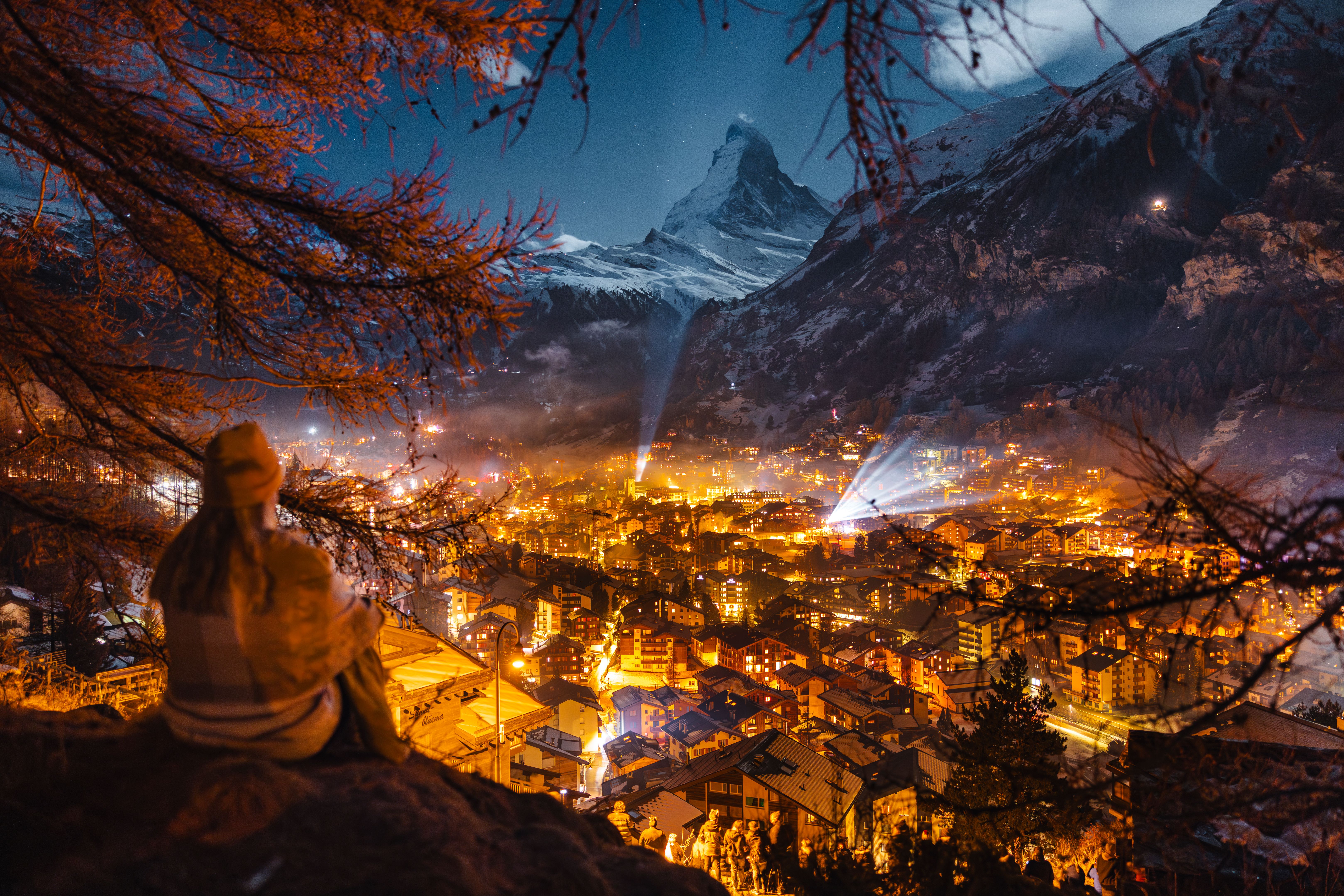 Female tourist enjoying looking over Zermatt and Matterhorn peak at winter night
