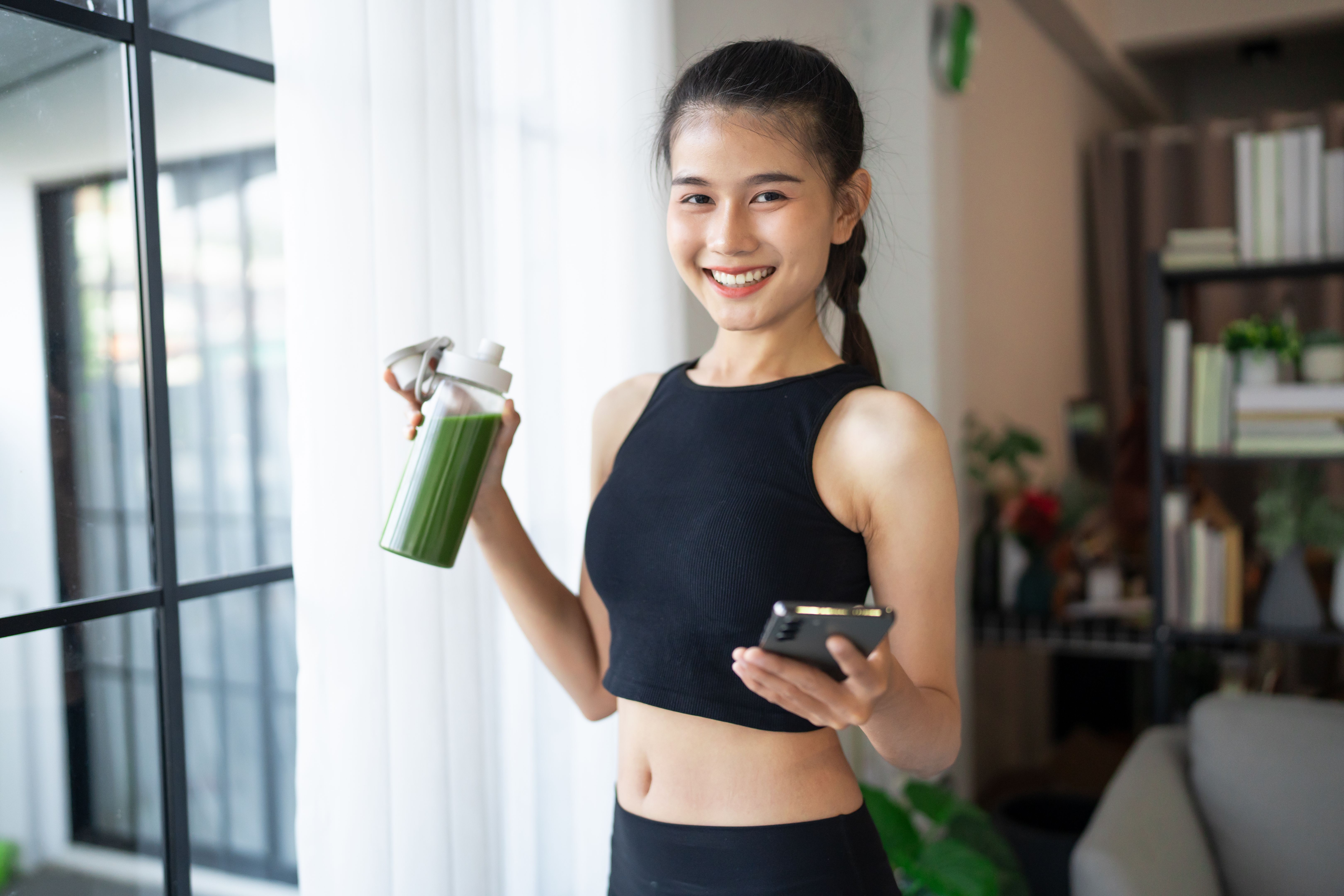 Fitness asian woman using smart phone and drinking organic green smoothie fruit detox for diet after workout exercise
training healthy lifestyle