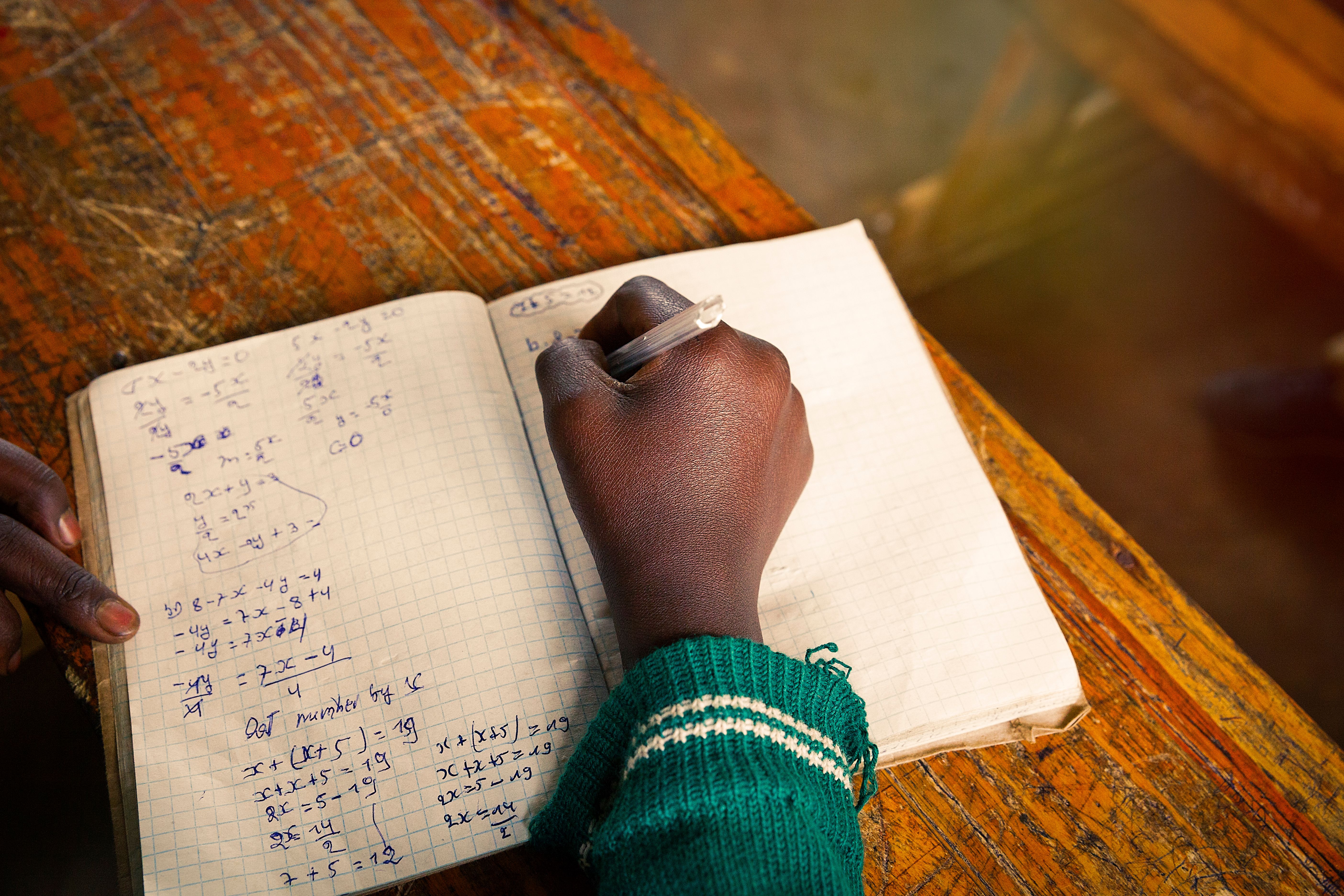 African student at school writing in his notebook