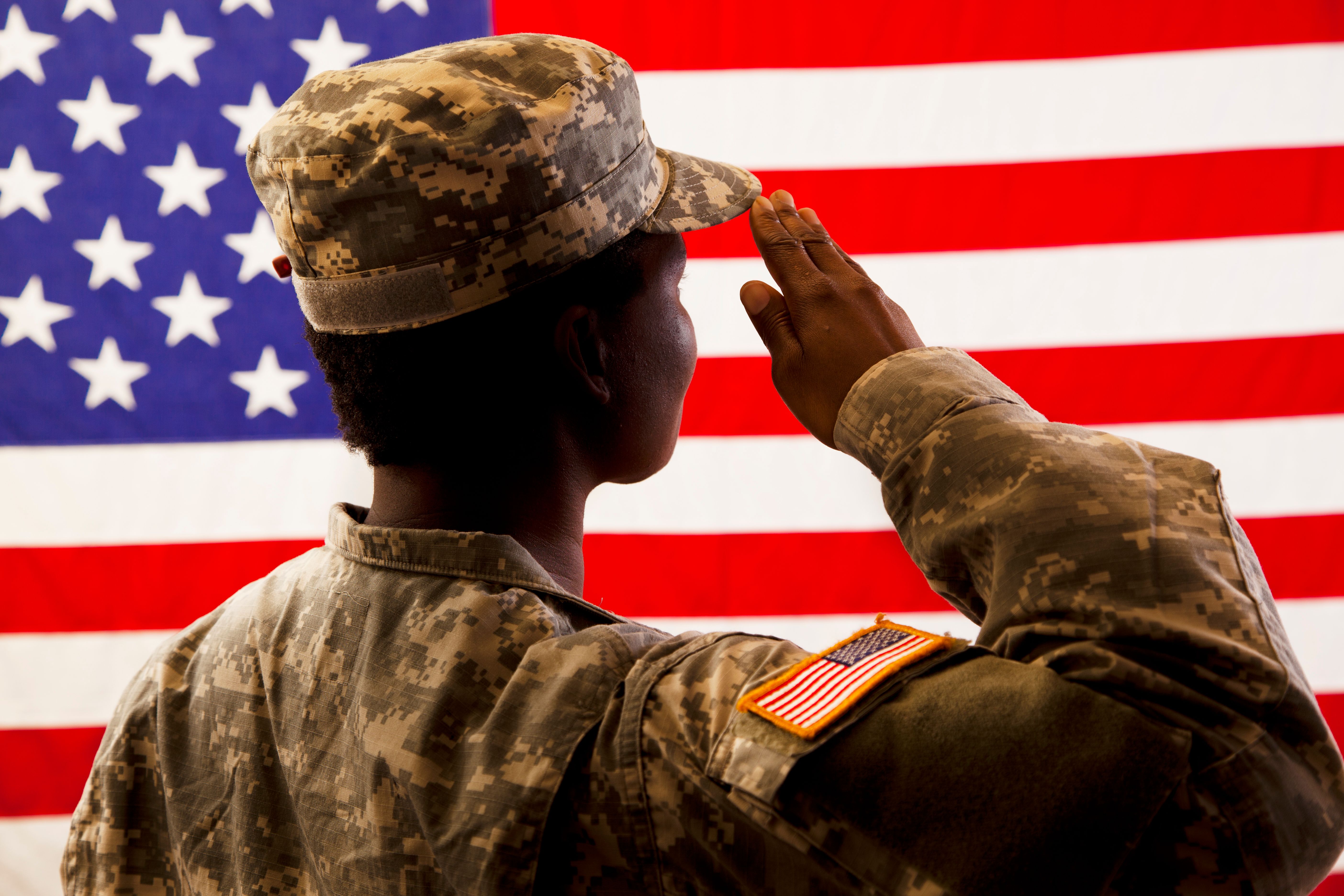 African American military woman salutes USA flag. African American military woman salutes USA flag.