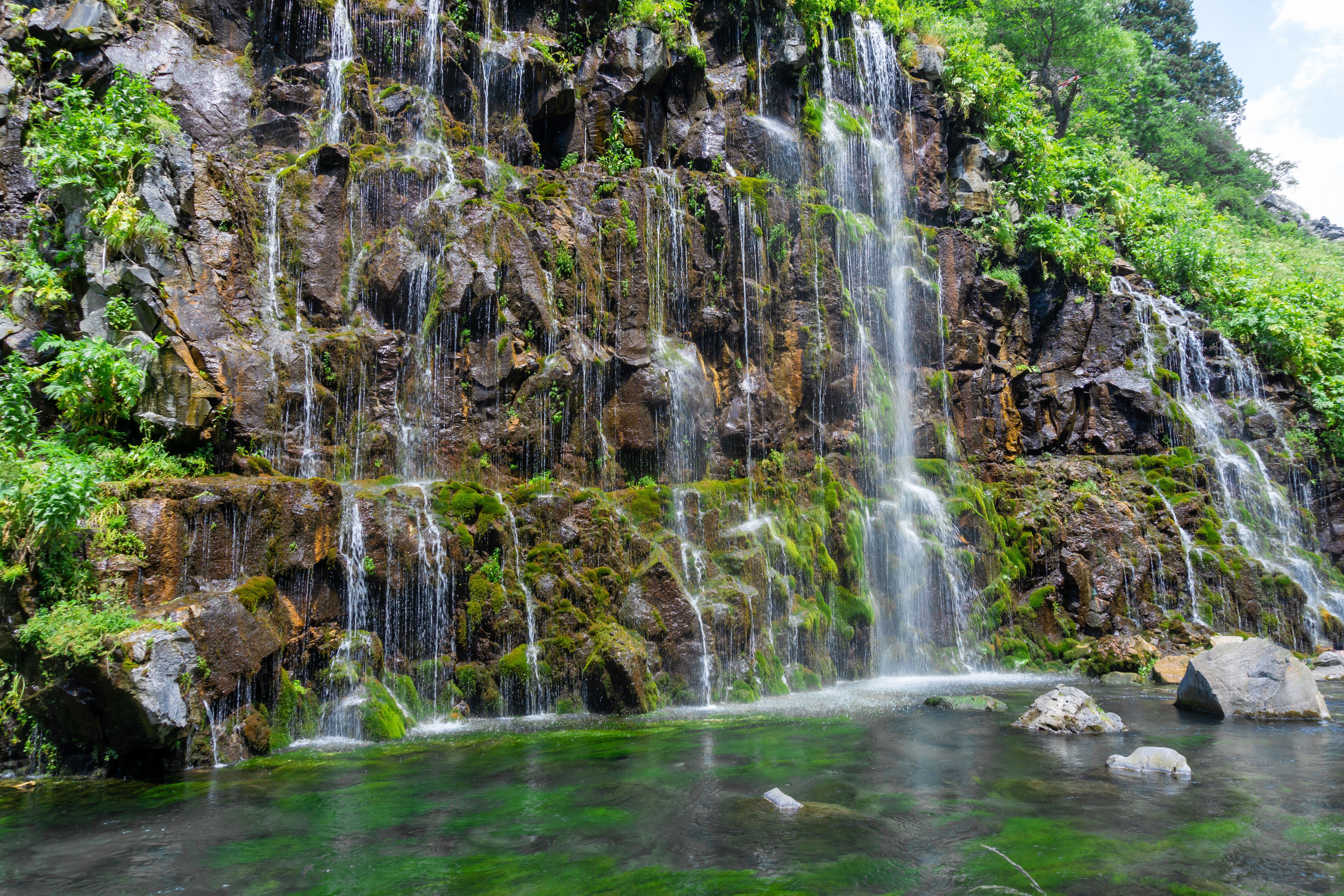 Many streams of water falling from a cliff into a lake. Tsalka canyon, Georgia
