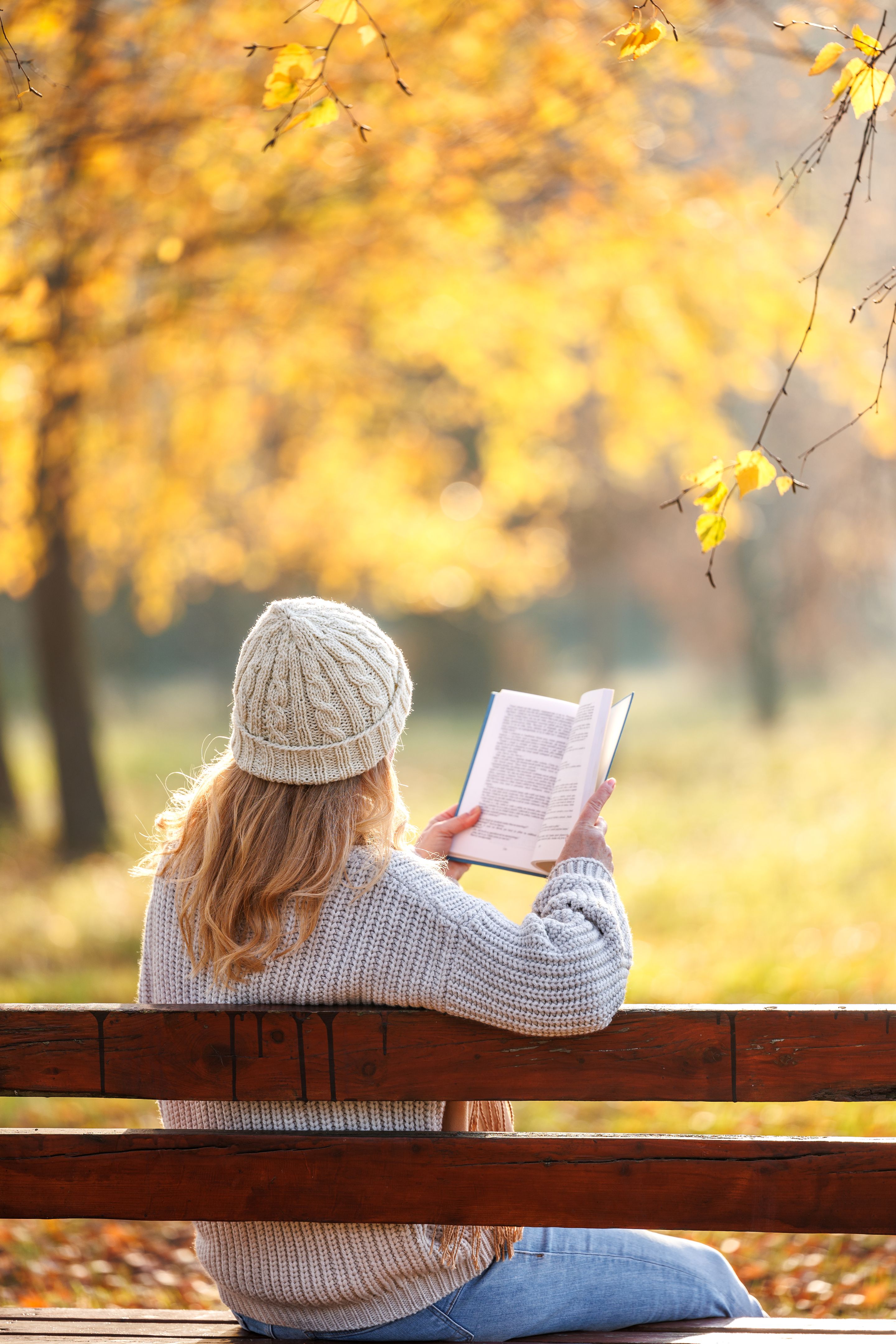 woman reading a book in autumn