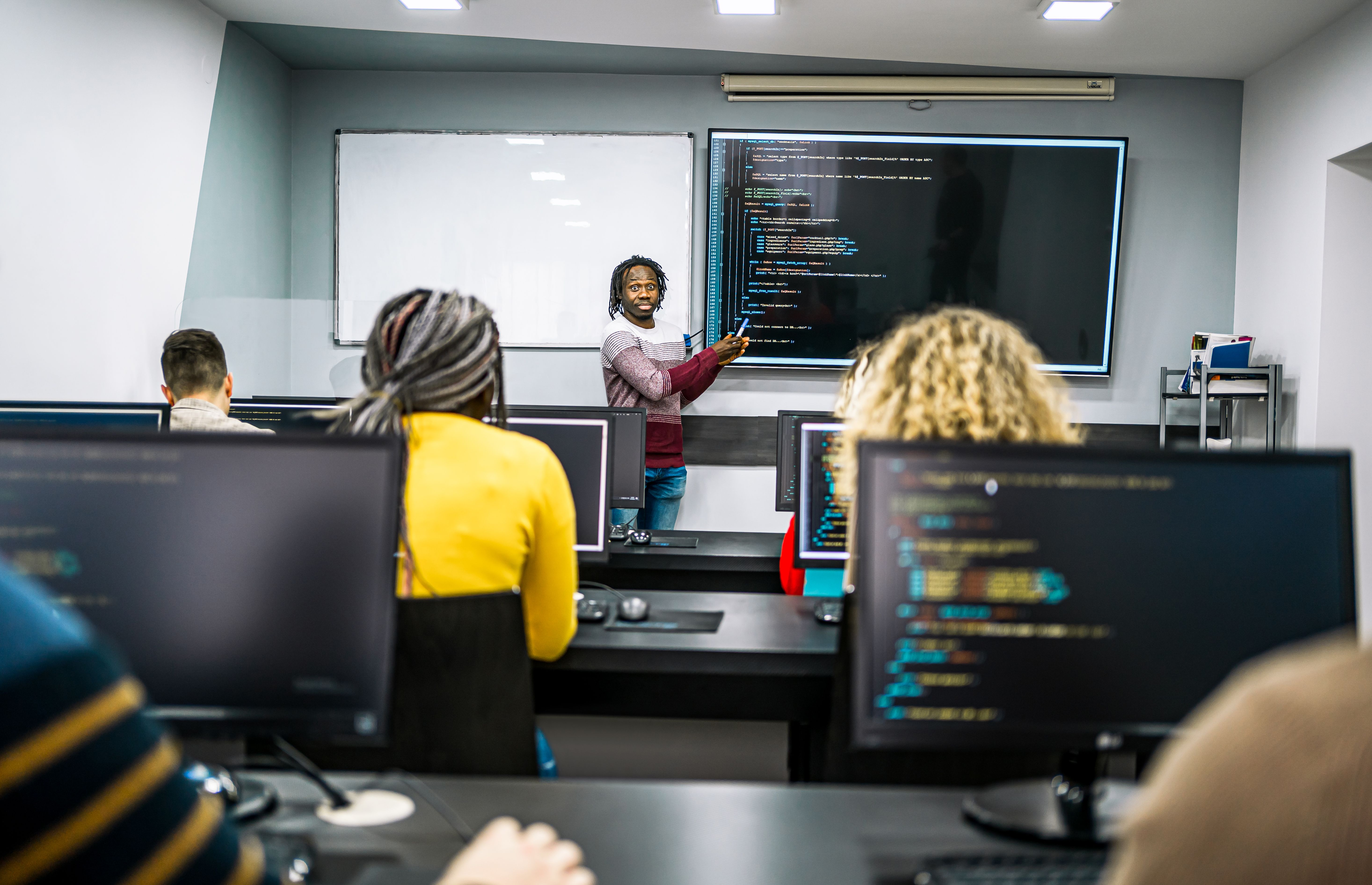 Male instructor teaching in a programming school