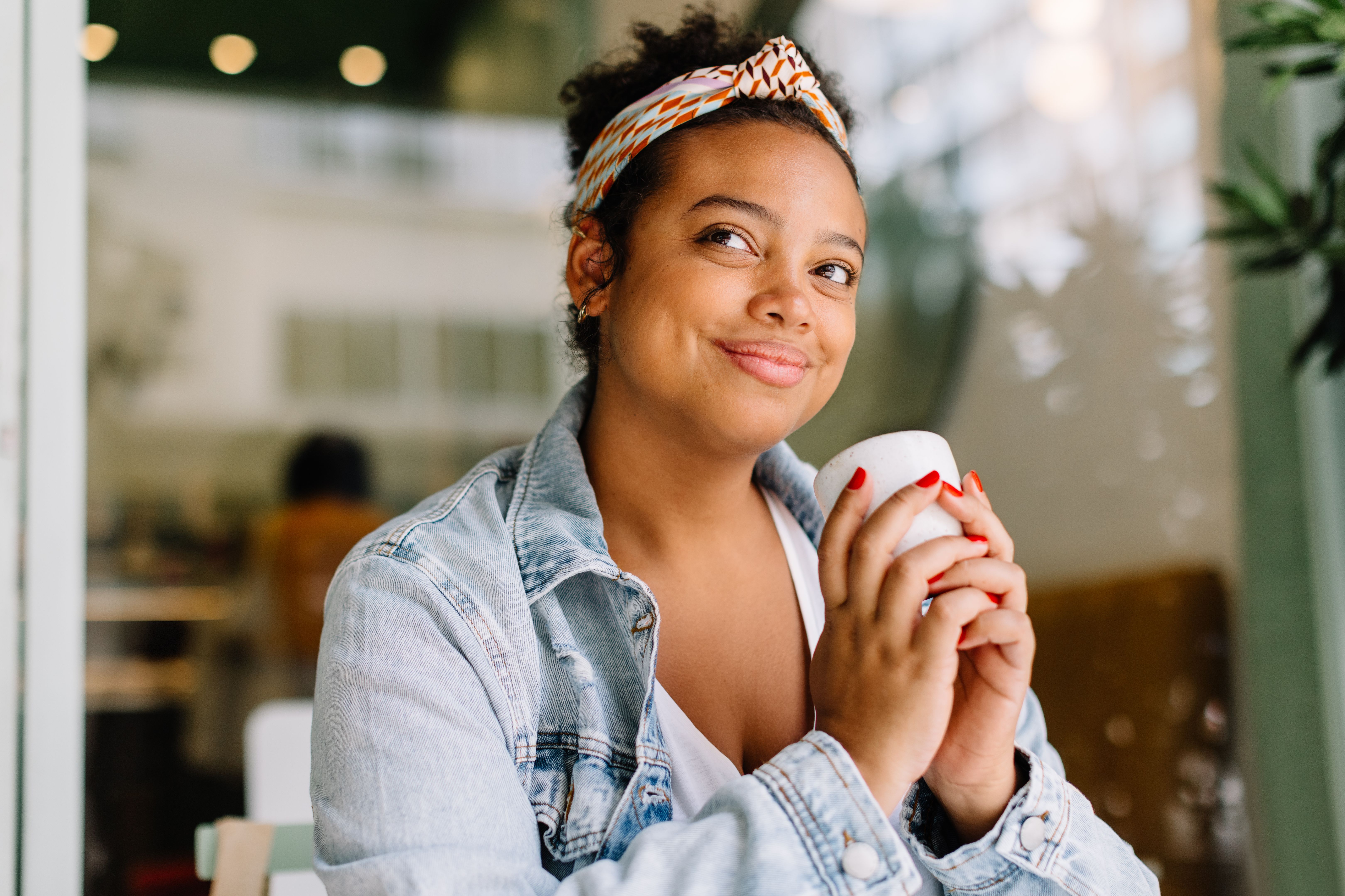 Young woman enjoying a hot beverage at a cozy coffee shop Young woman enjoying a hot beverage at a cozy coffee shop