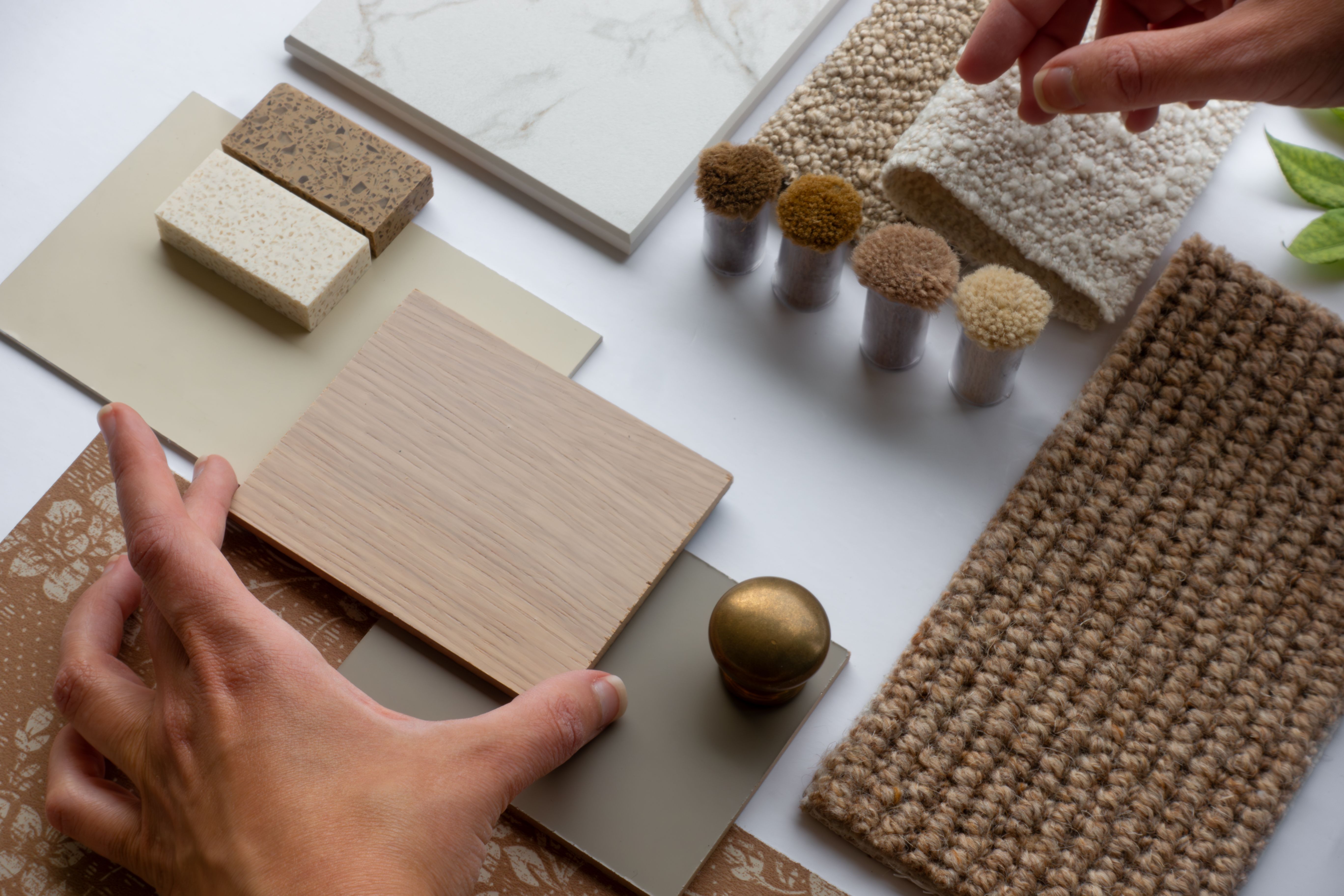 Hand of Interior Designer and Architect placing wood sample on Material Board