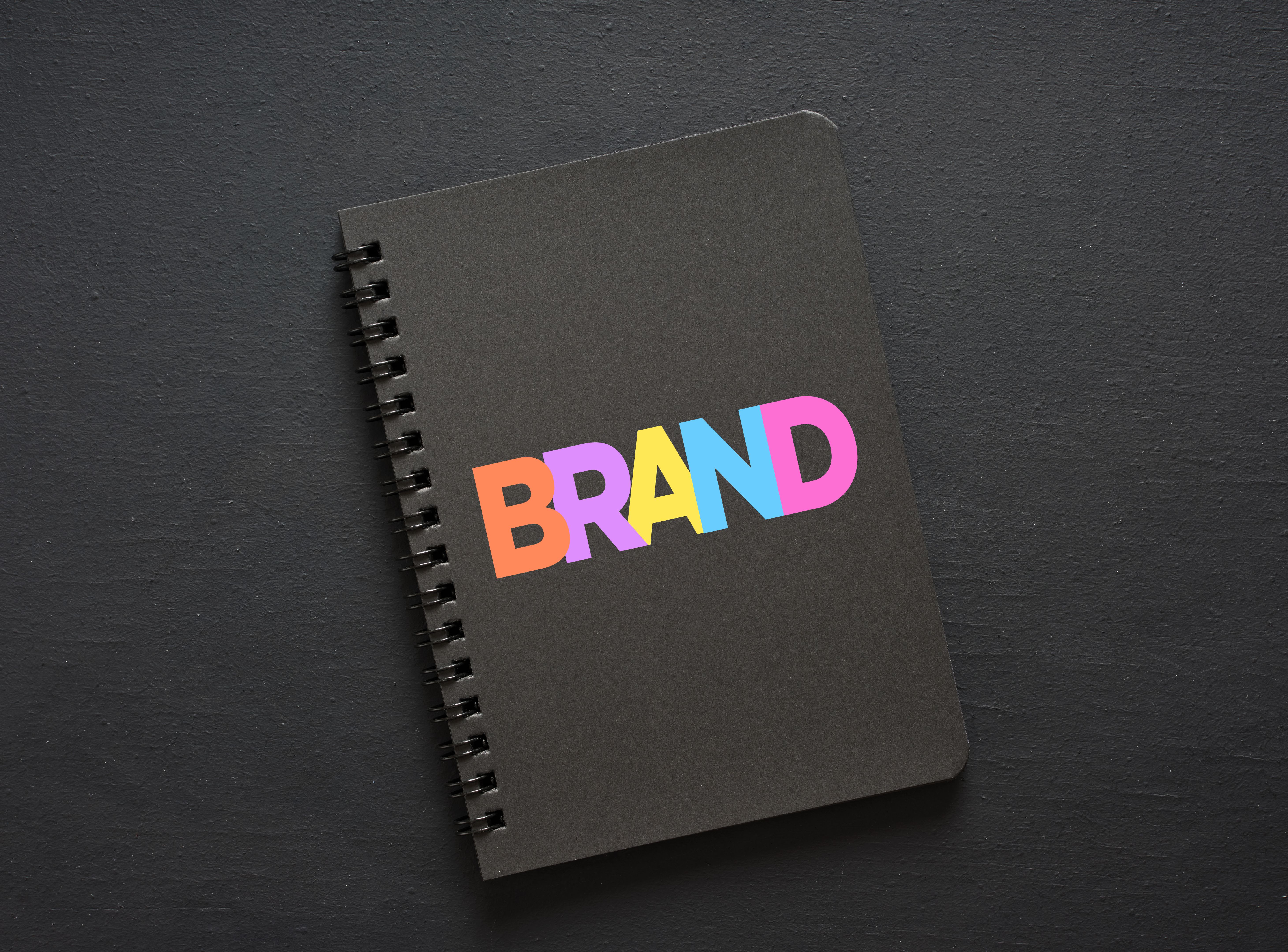Black notebook showing brand concept on dark background