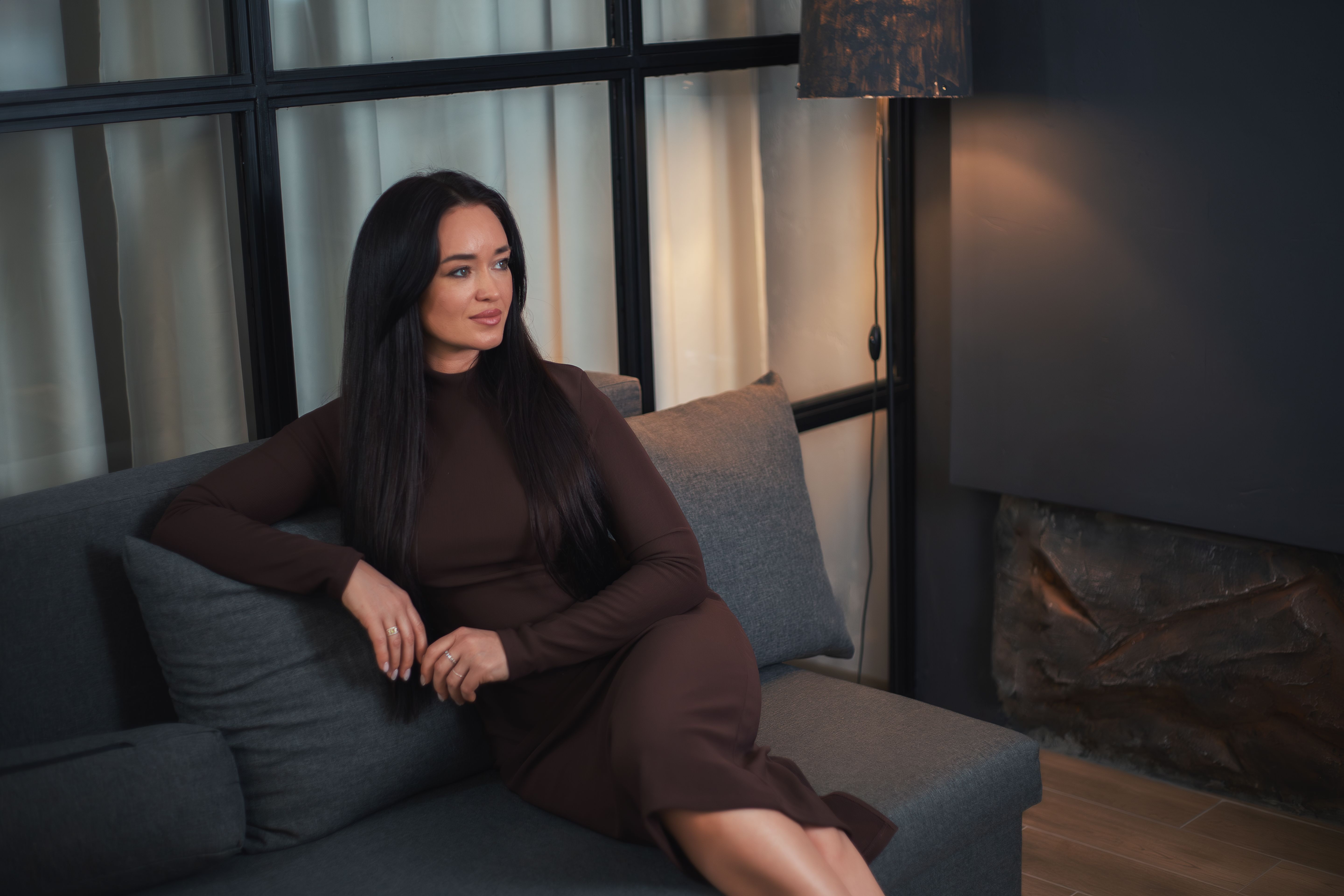 Smiling young woman in evening dress in a cozy setting