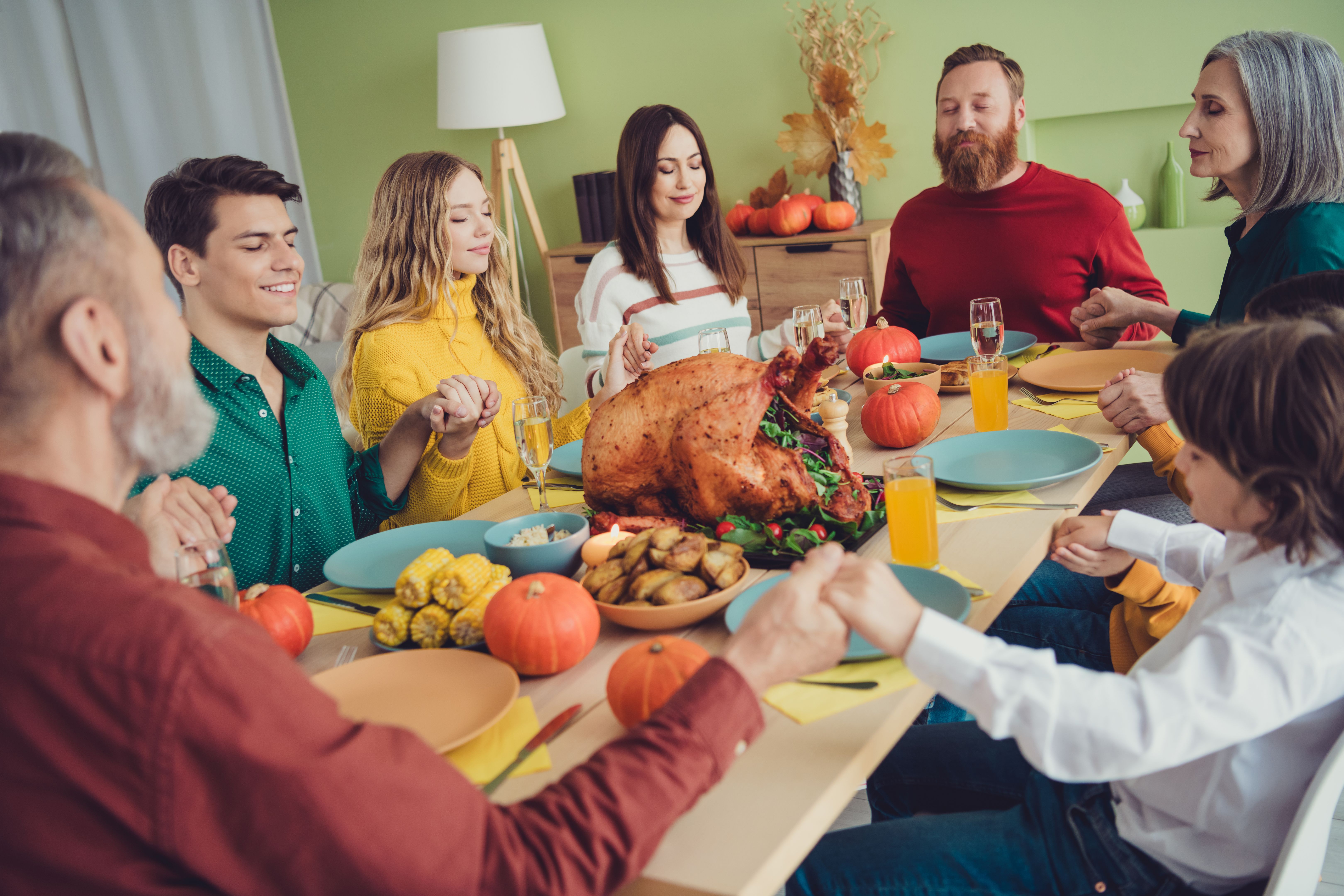Photo of nice big family enjoying thanksgiving day gathering together praying appreciating eating lunch indoors Photo of nice big family enjoying thanksgiving day gathering together praying appreciating eating lunch indoors