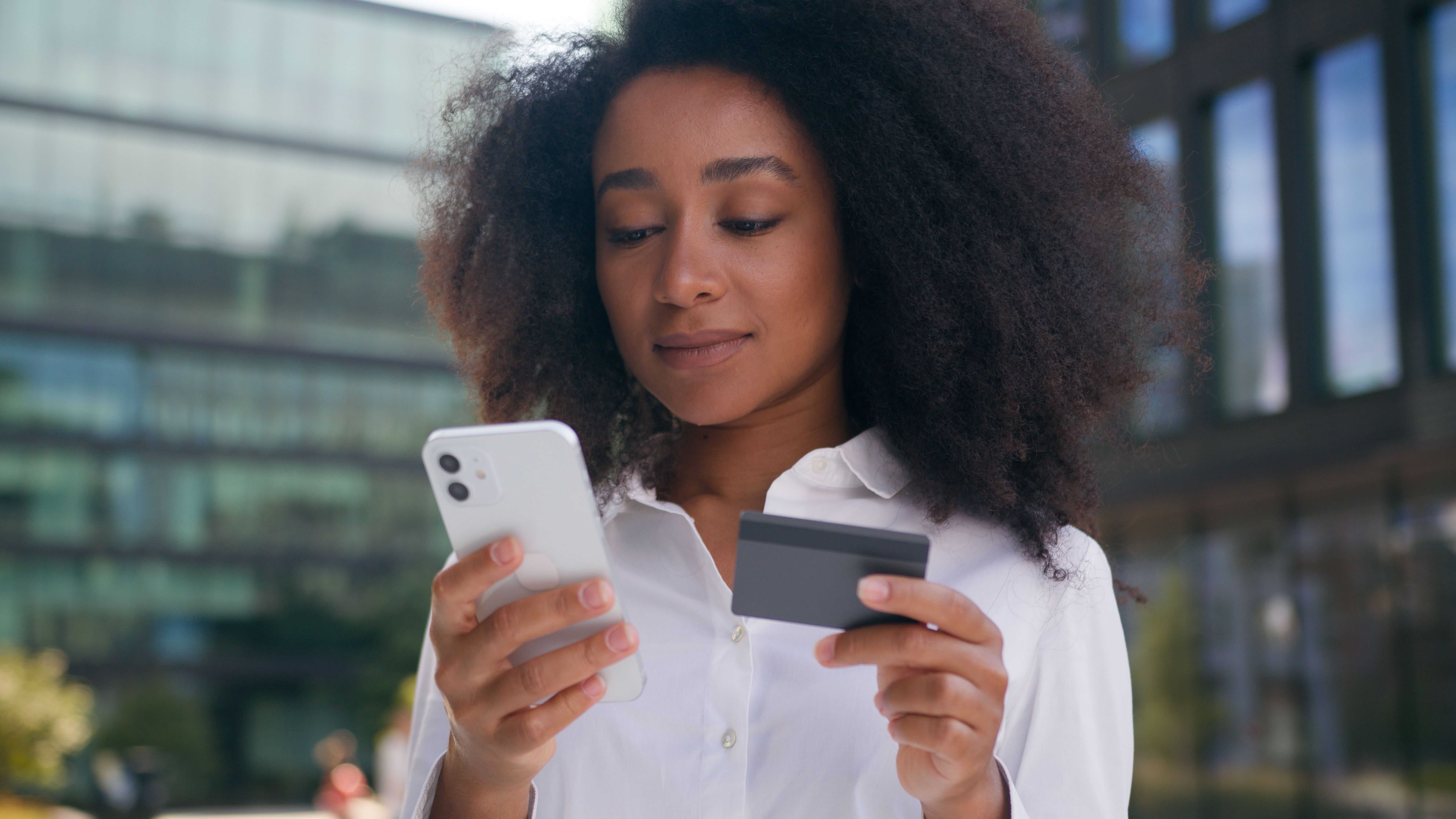 African American woman businesswoman using mobile phone smartphone bank card investment paying online girl finance debit loan shopping business ecommerce technology internet credit female money city