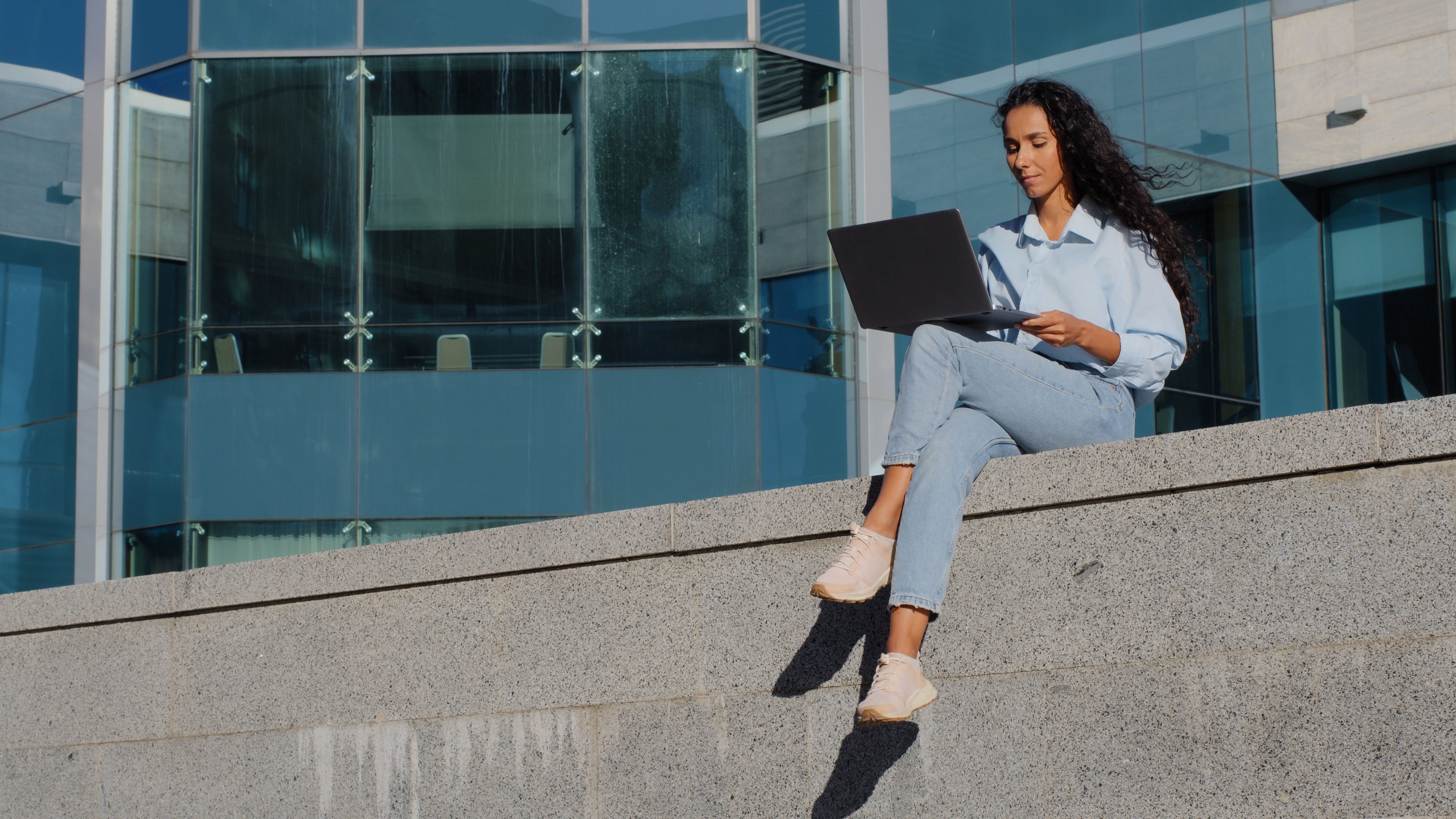 Successful business woman girl student sitting city building skyscraper modern creative company background working on street closes laptop taking break finishing studying online resting relaxing Successful business woman girl student sitting city building skyscraper modern creative company background working on street closes laptop taking break finishing studying online resting relaxing