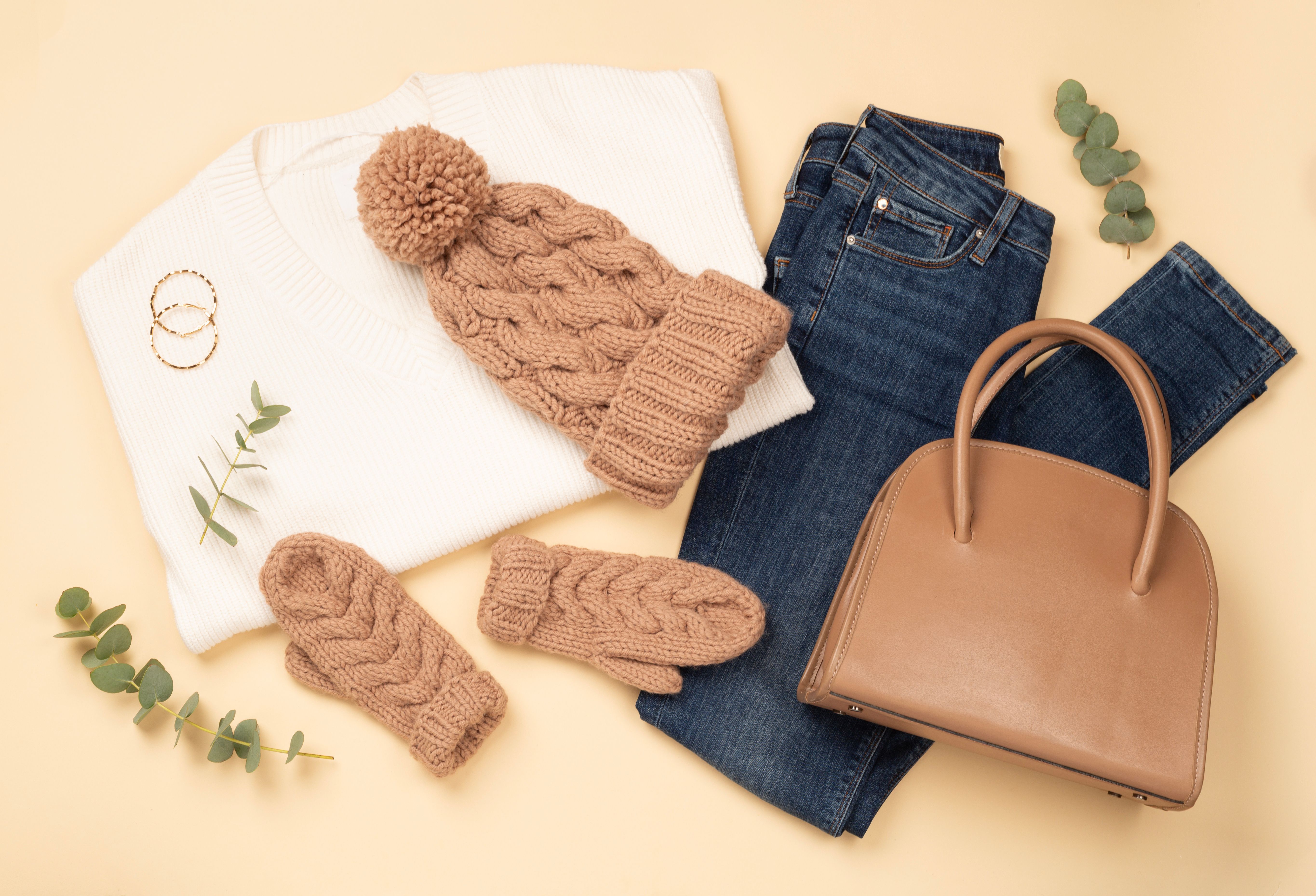 Flat lay with women's trendy spring outfit on beige background, top view