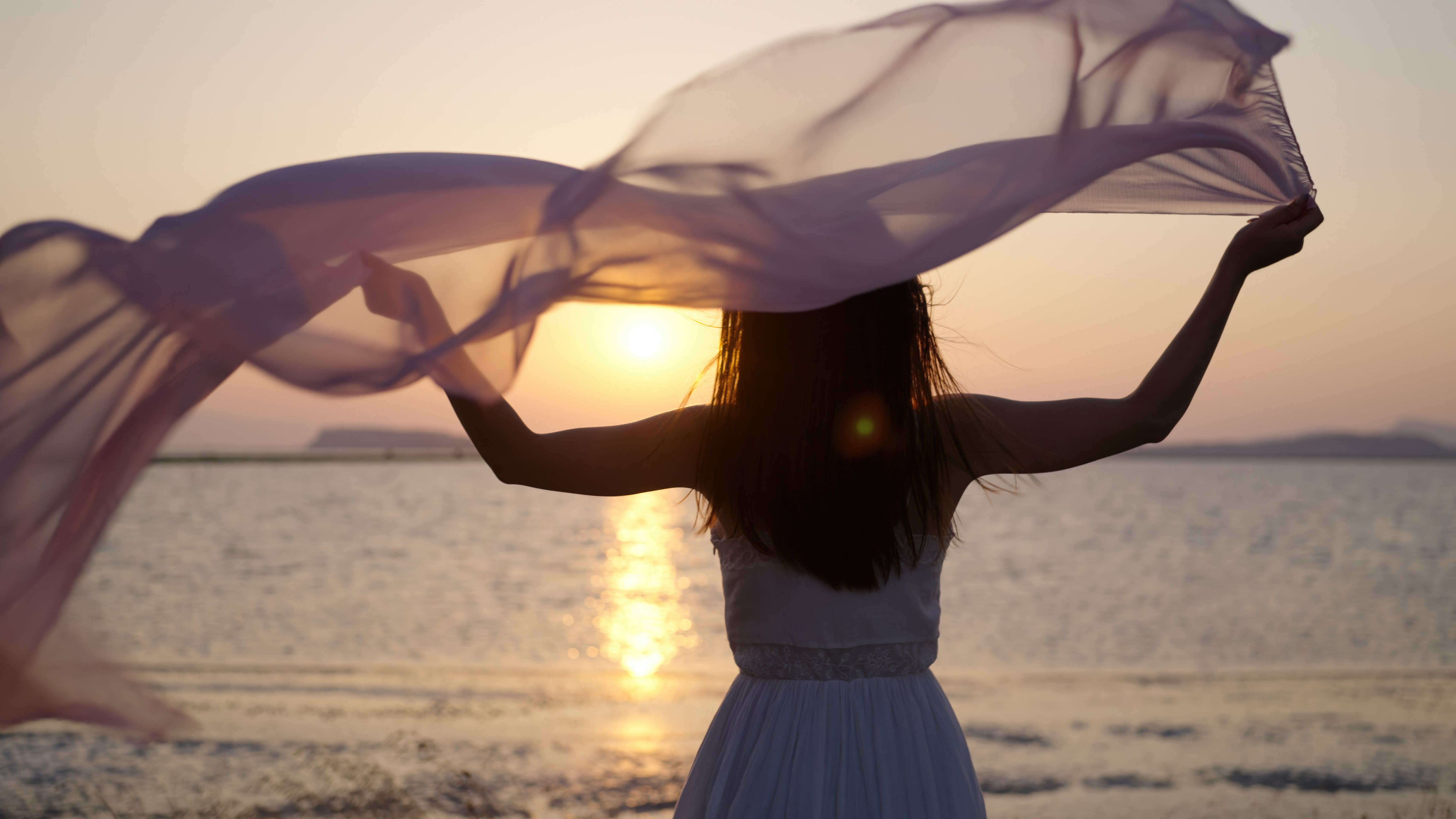 Young woman waving silk in air