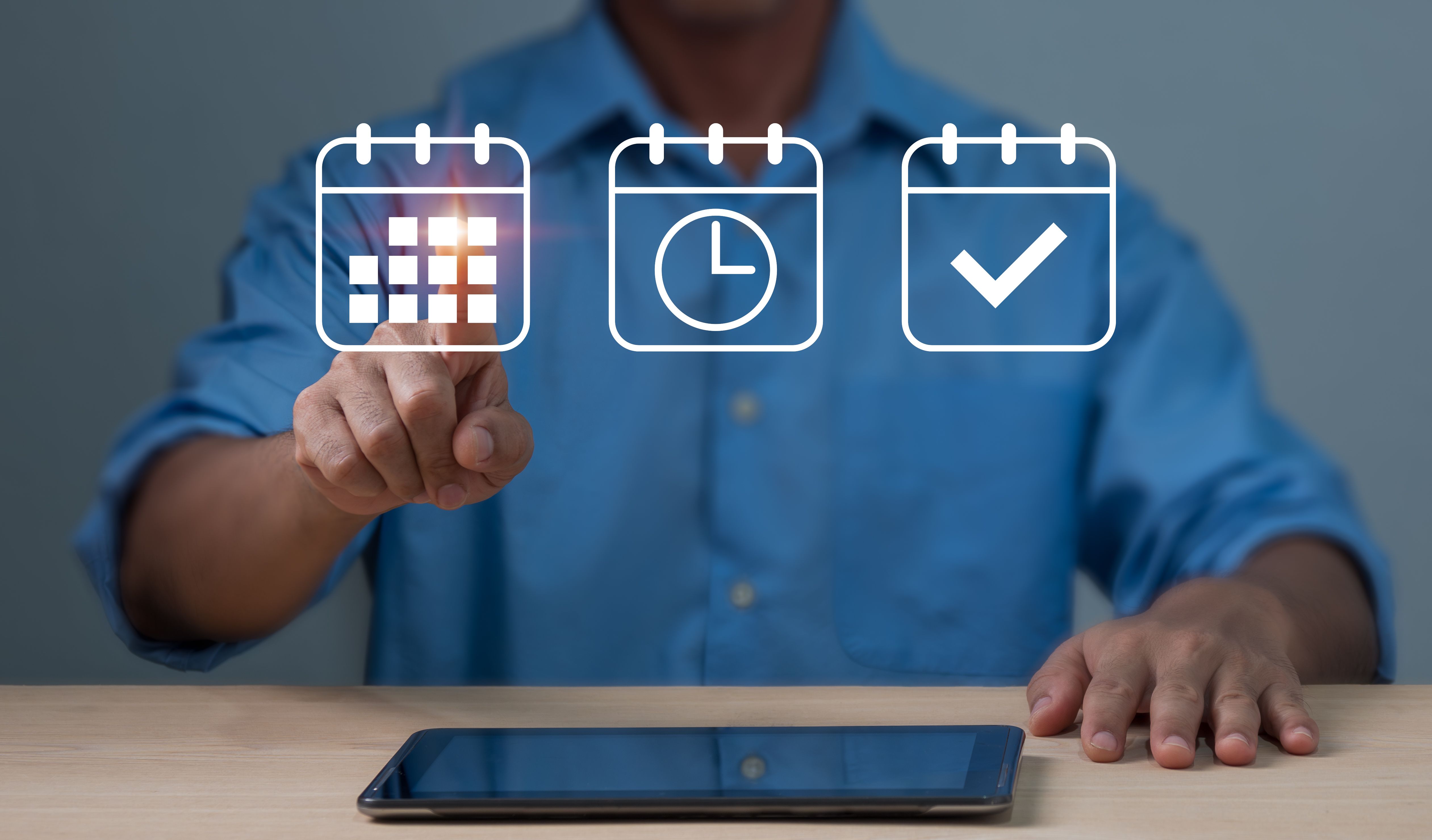 reminding the organizer of the appointments listed in the agenda and on the calendar.Event planners utilize agendas and schedules to plan and coordinate events.The man is pointing at calendar symbol.