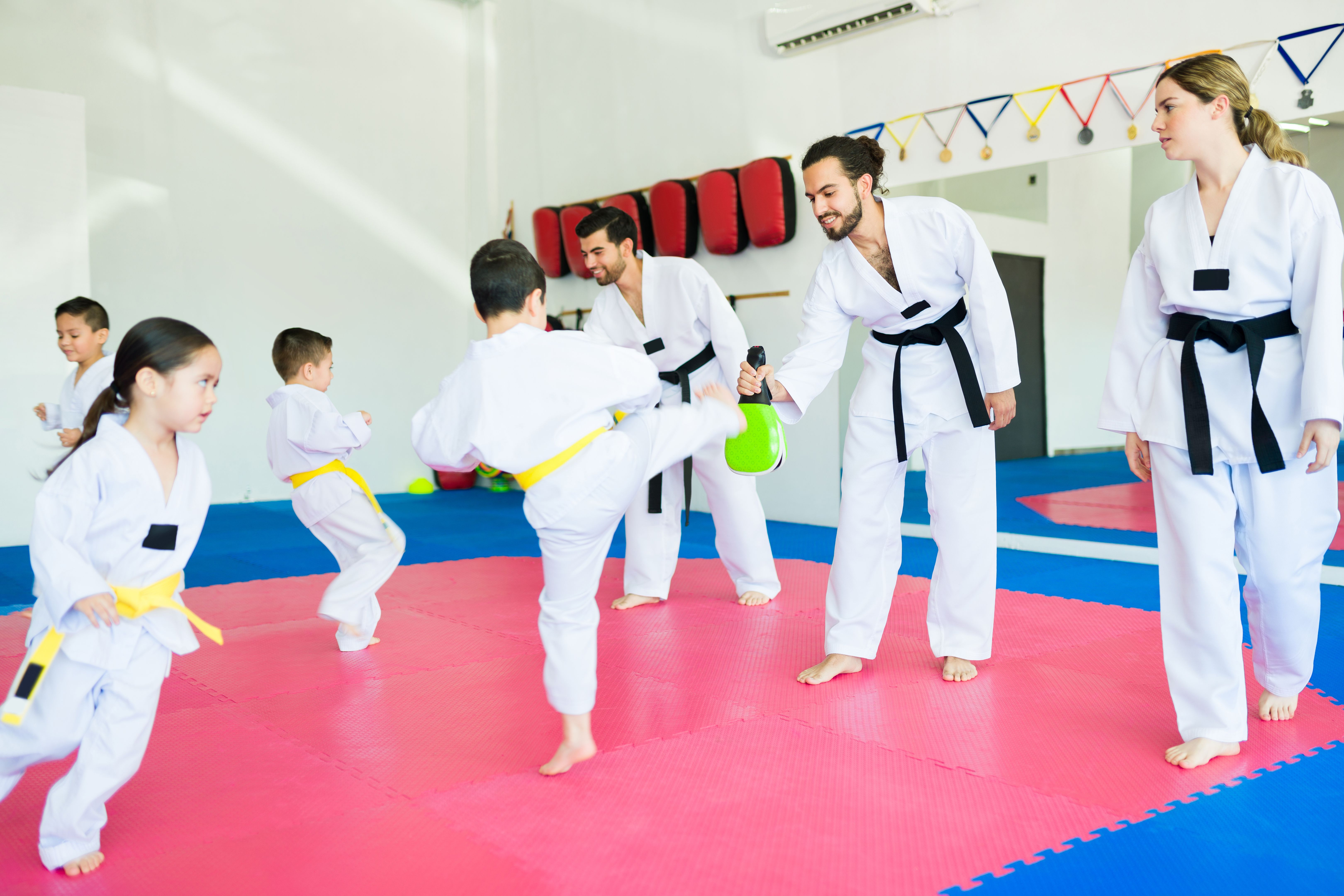 Karate trainers practicing taekwondo with children
