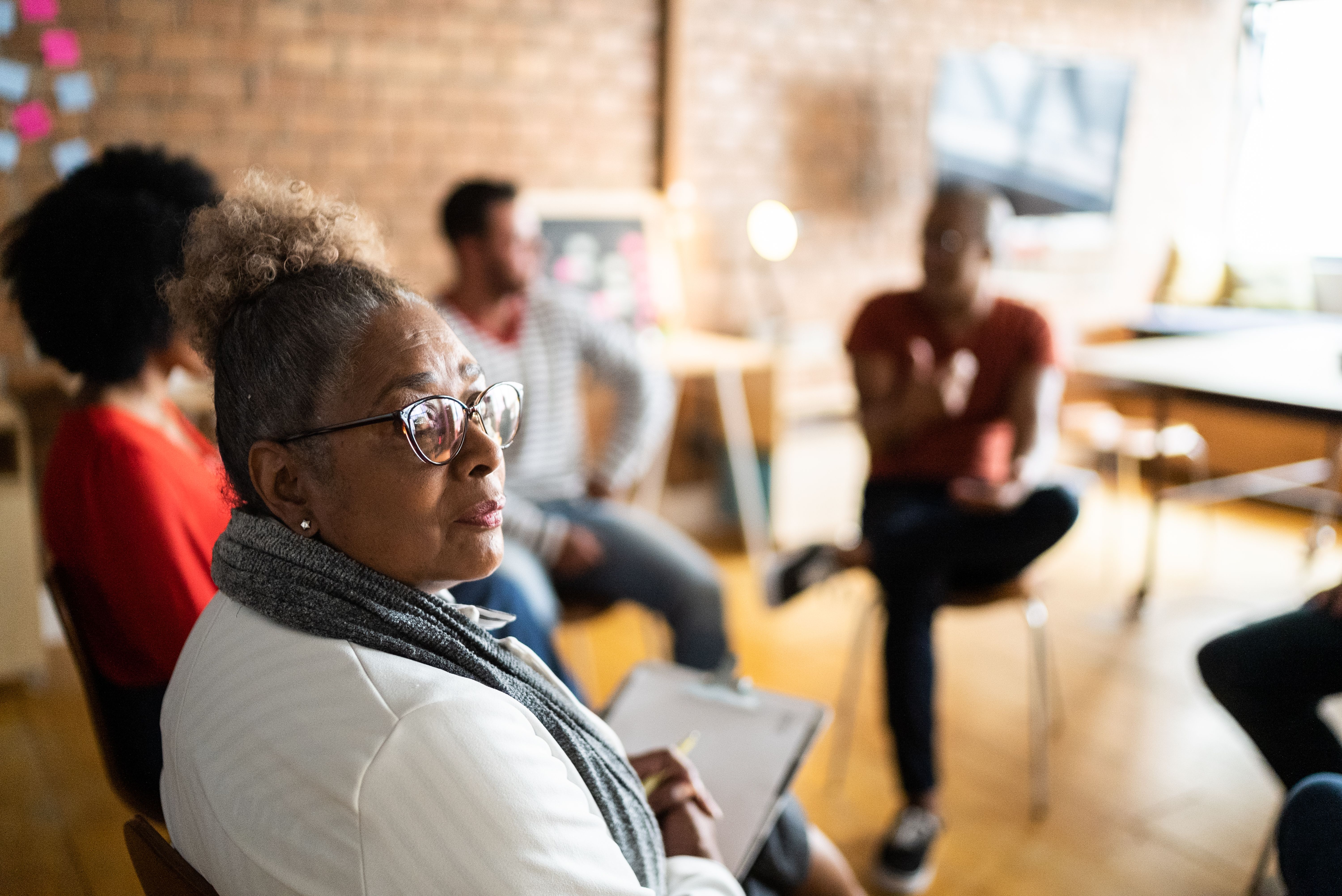 Portrait of a senior woman in group therapy or business meeting Portrait of a senior woman in group therapy or business meeting