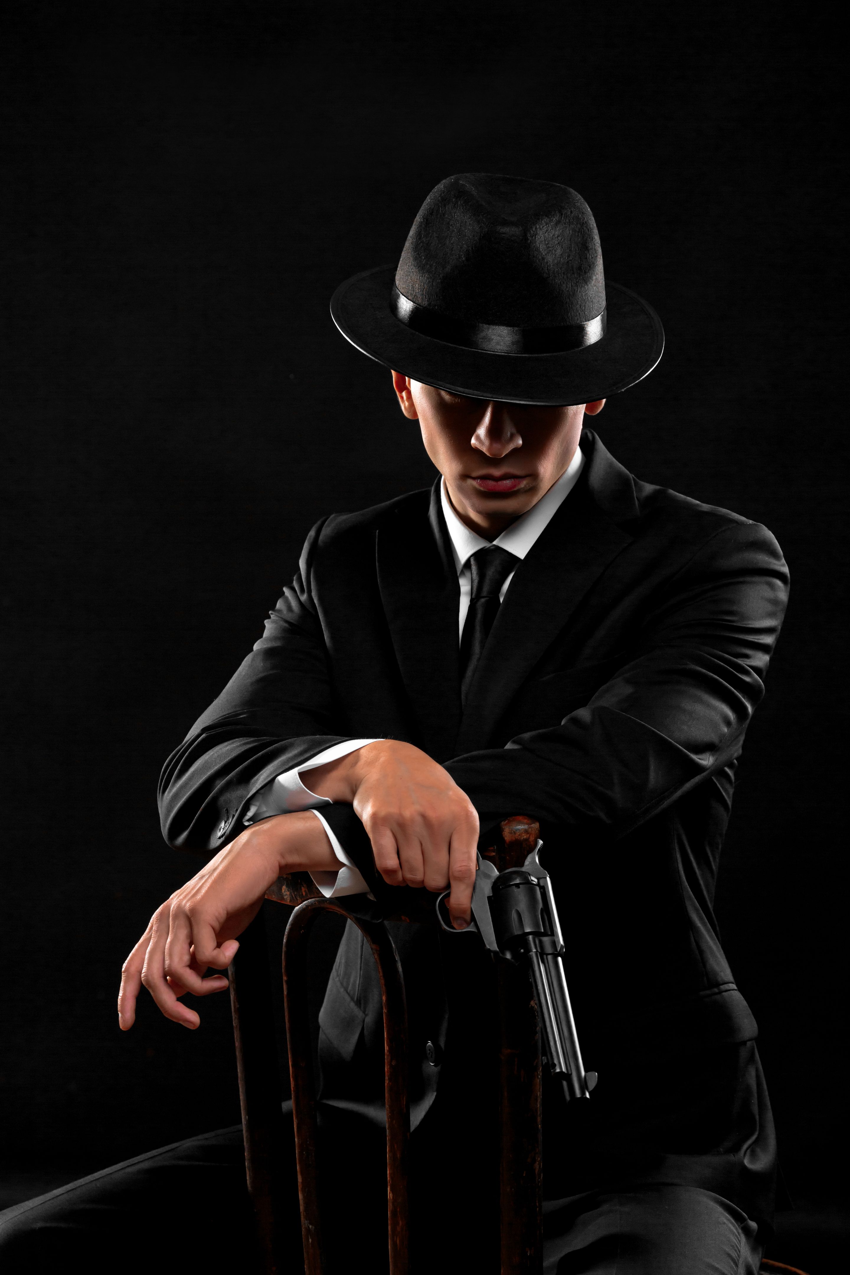 Vertical portrait of gangster from 1940s with a gun.