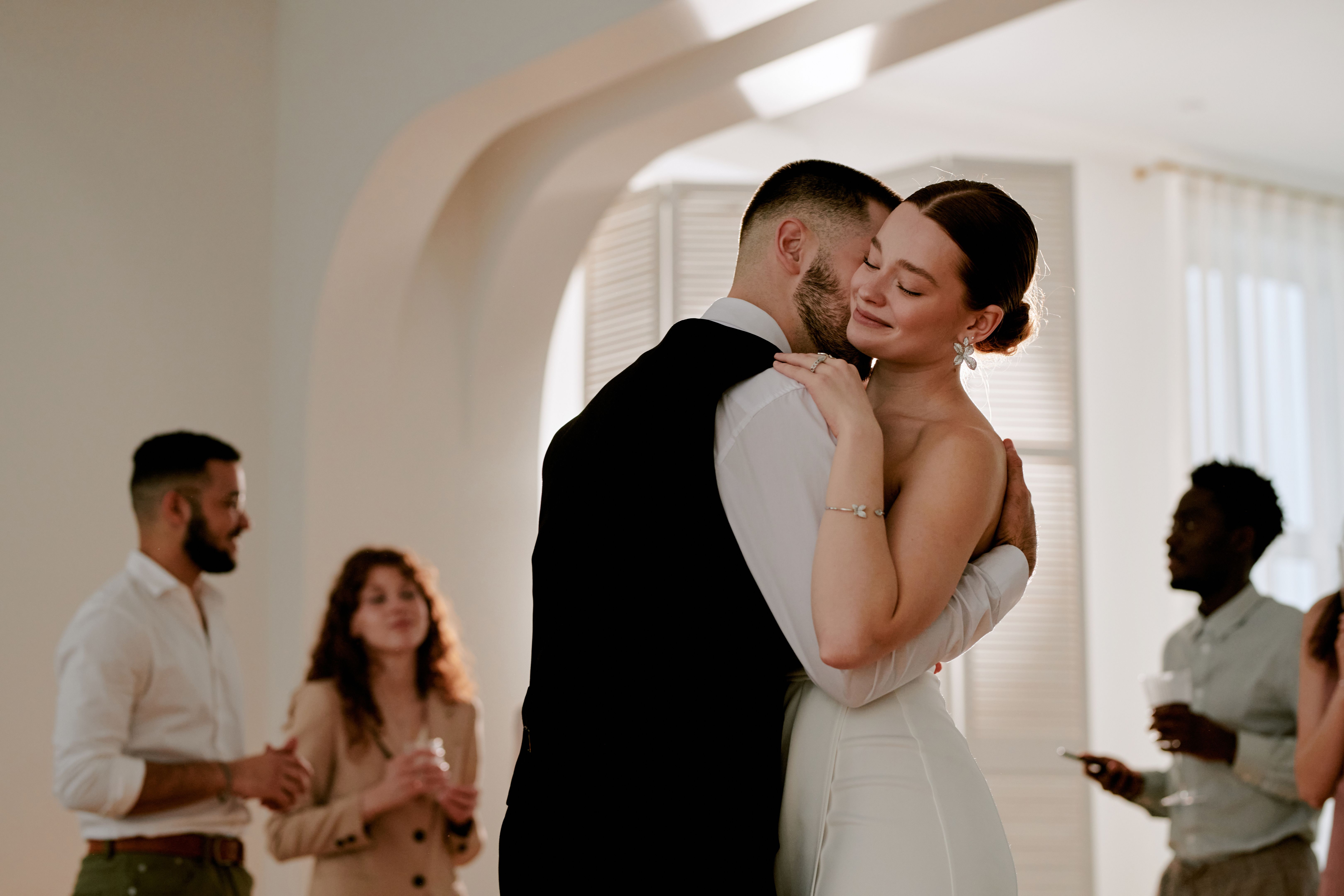 Young Caucasian Bride and Groom Embracing during Wedding Celebration Indoors