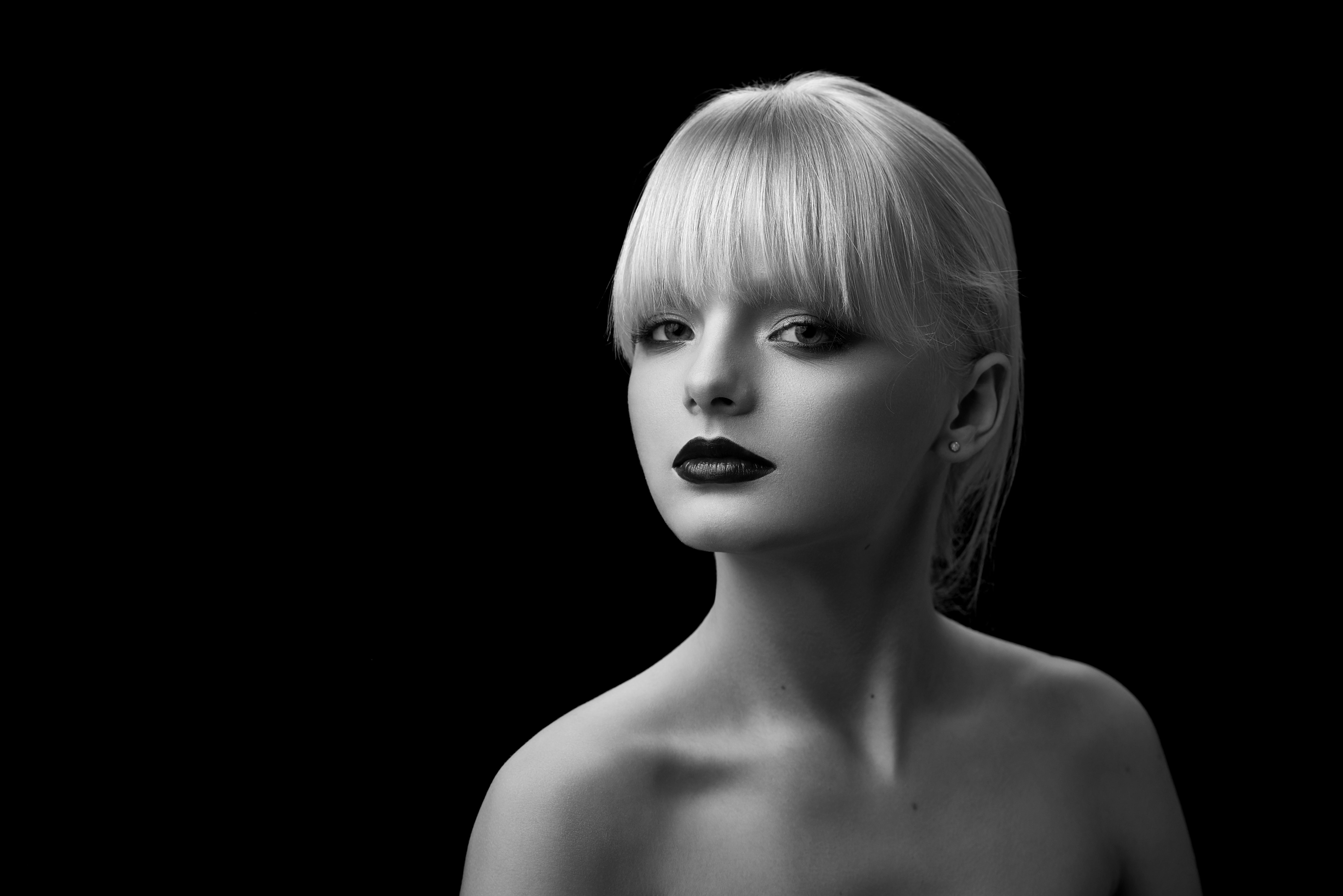 Black and white portrait of pretty girl with blonde hair and evening make up.