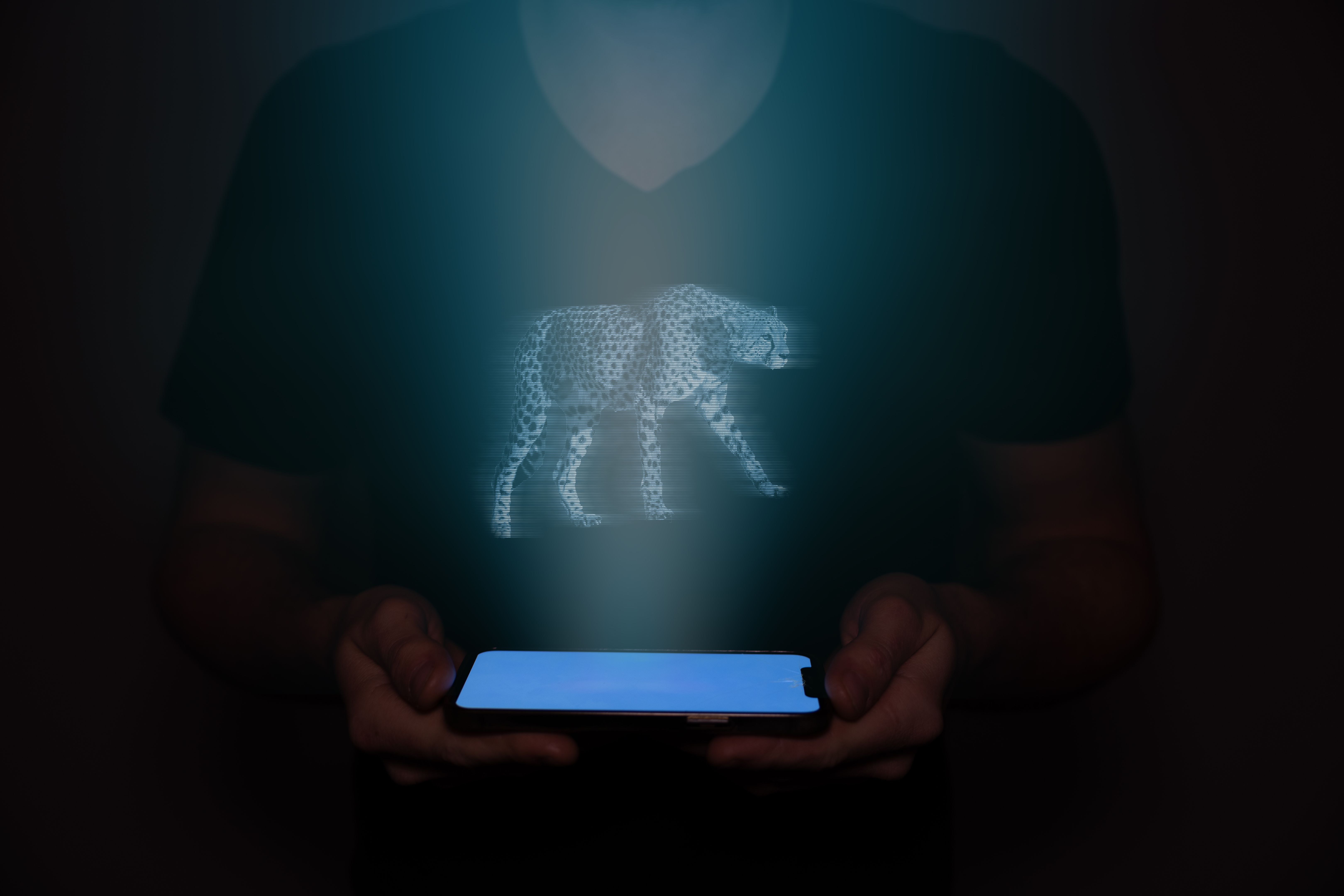 A hologram of a cheetah projected onto a cellphone held by a man from the future.