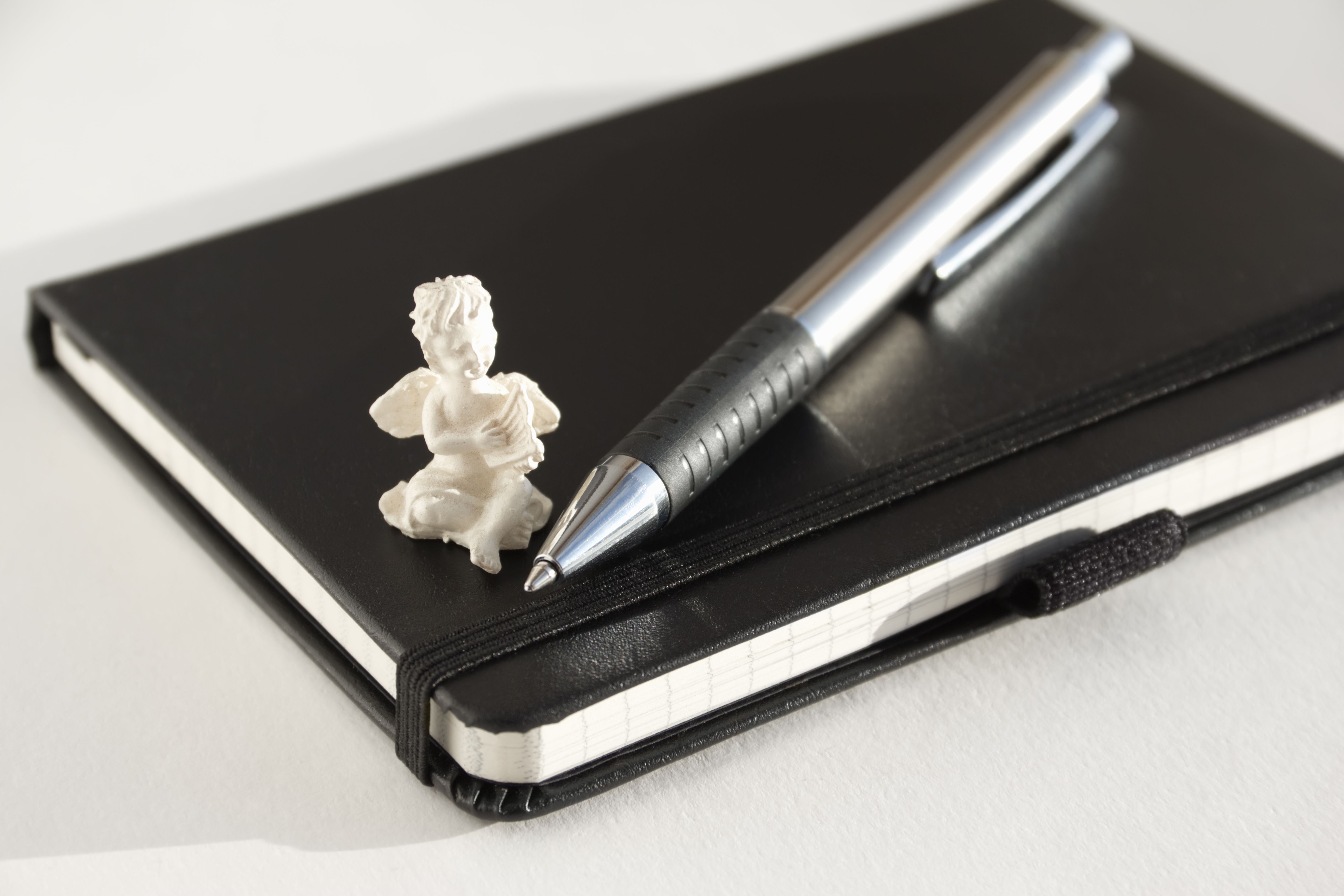 Cuaderno con una pluma y la figura de un ángel Cuaderno con una pluma y la figura de un ángel