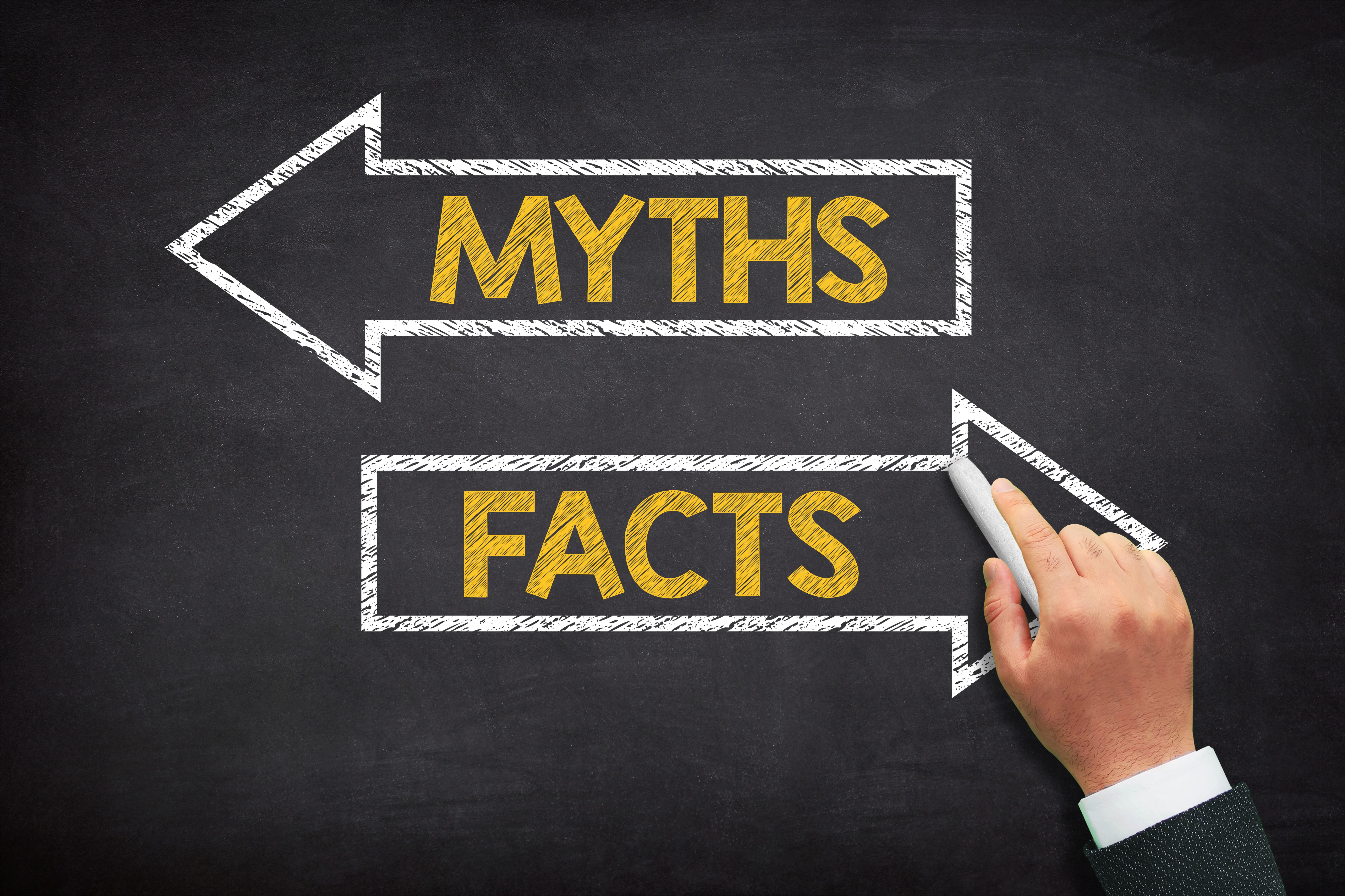 Myths and facts concept. Myths and facts written on a black chalkboard.