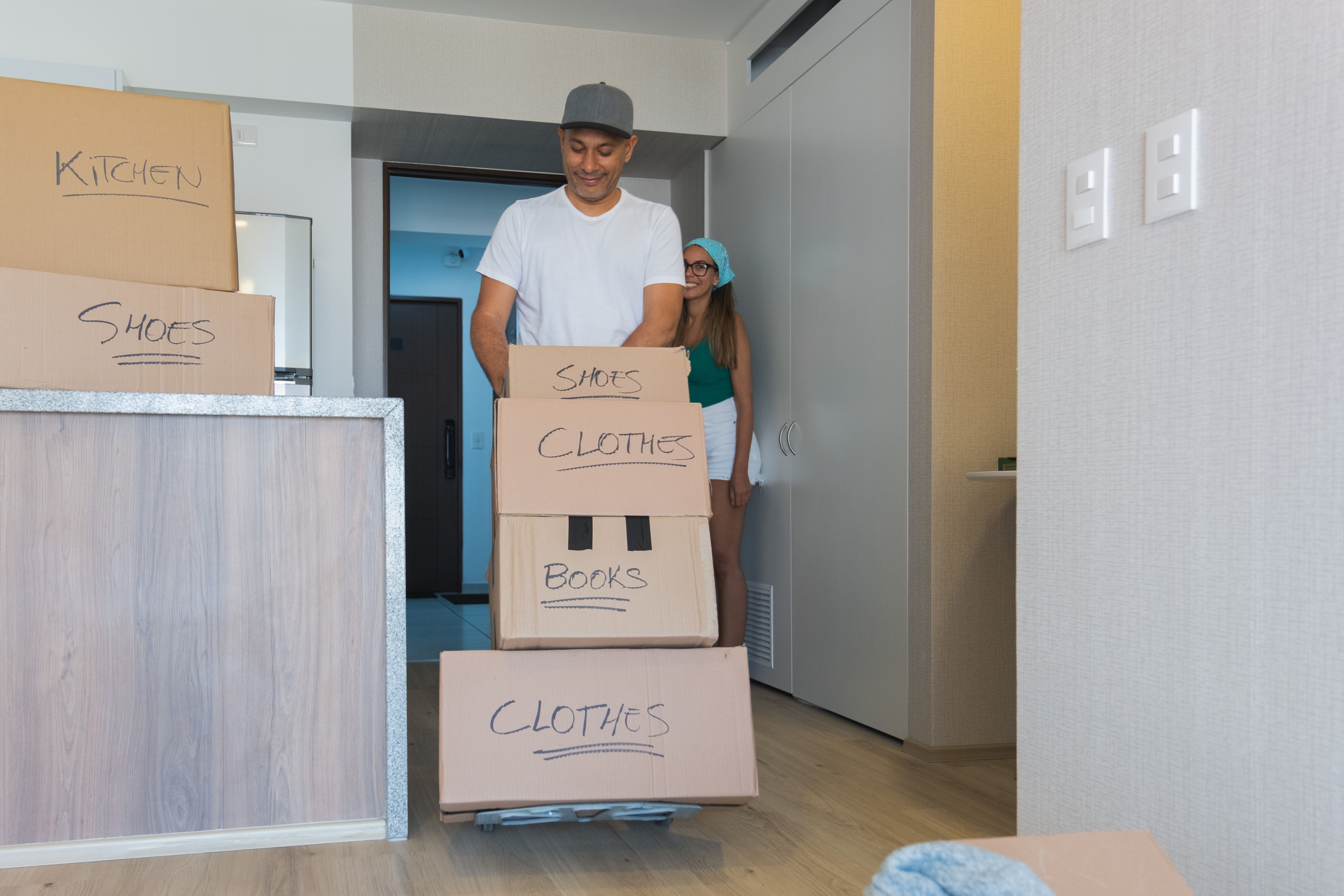 A man and a woman are moving boxes into a new apartment. New home concept.