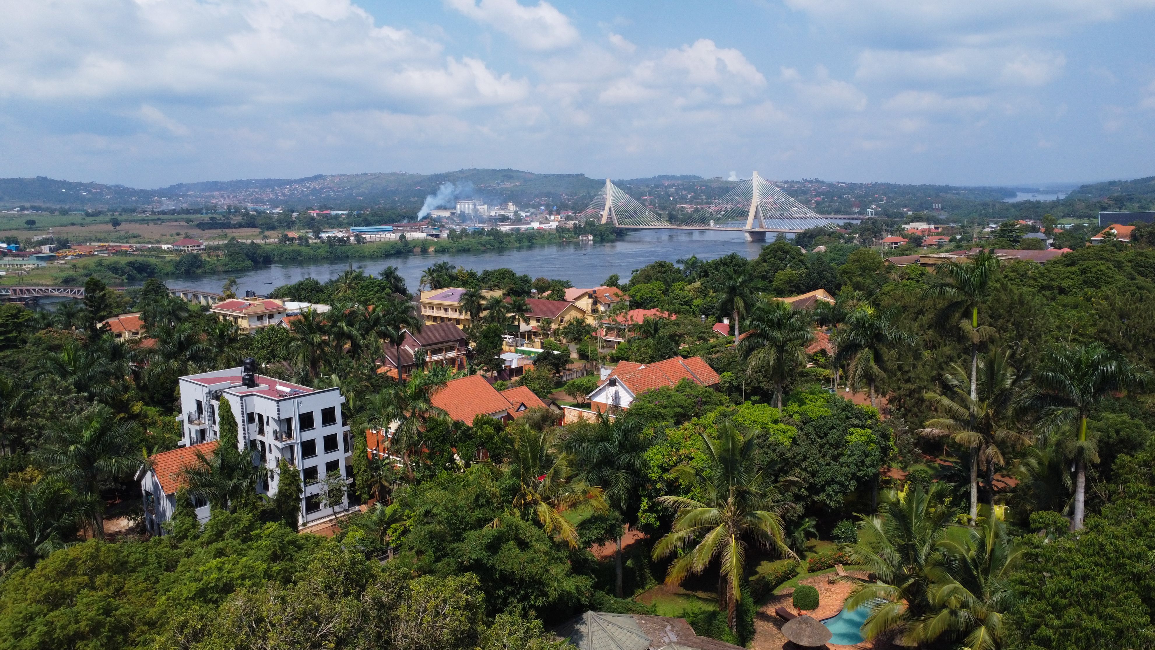 Uganda Landscape Featuring Nile River, Jinja Bridge, Lush Greenery, and Residential Buildings
