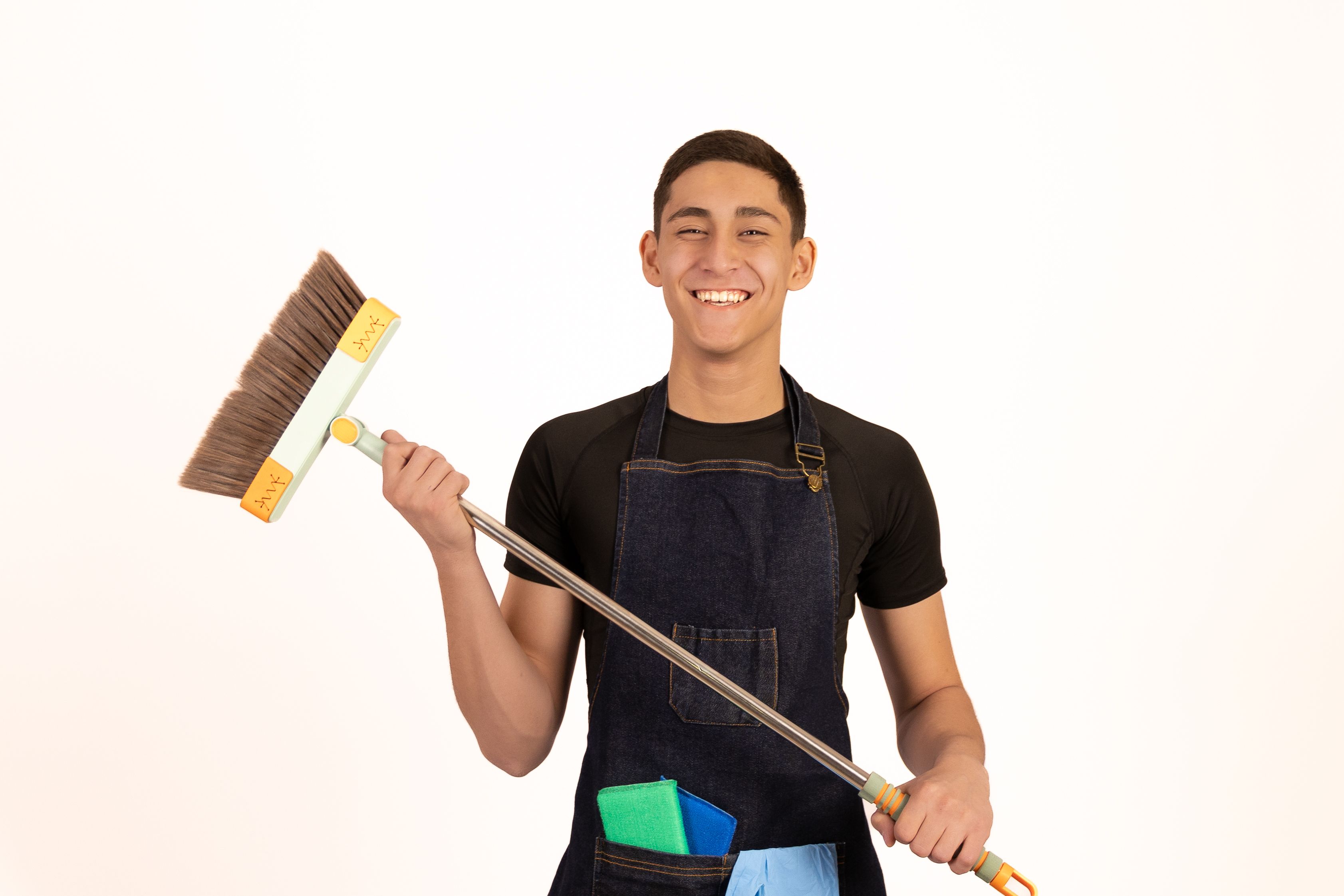 Young man holding a broom and smiling