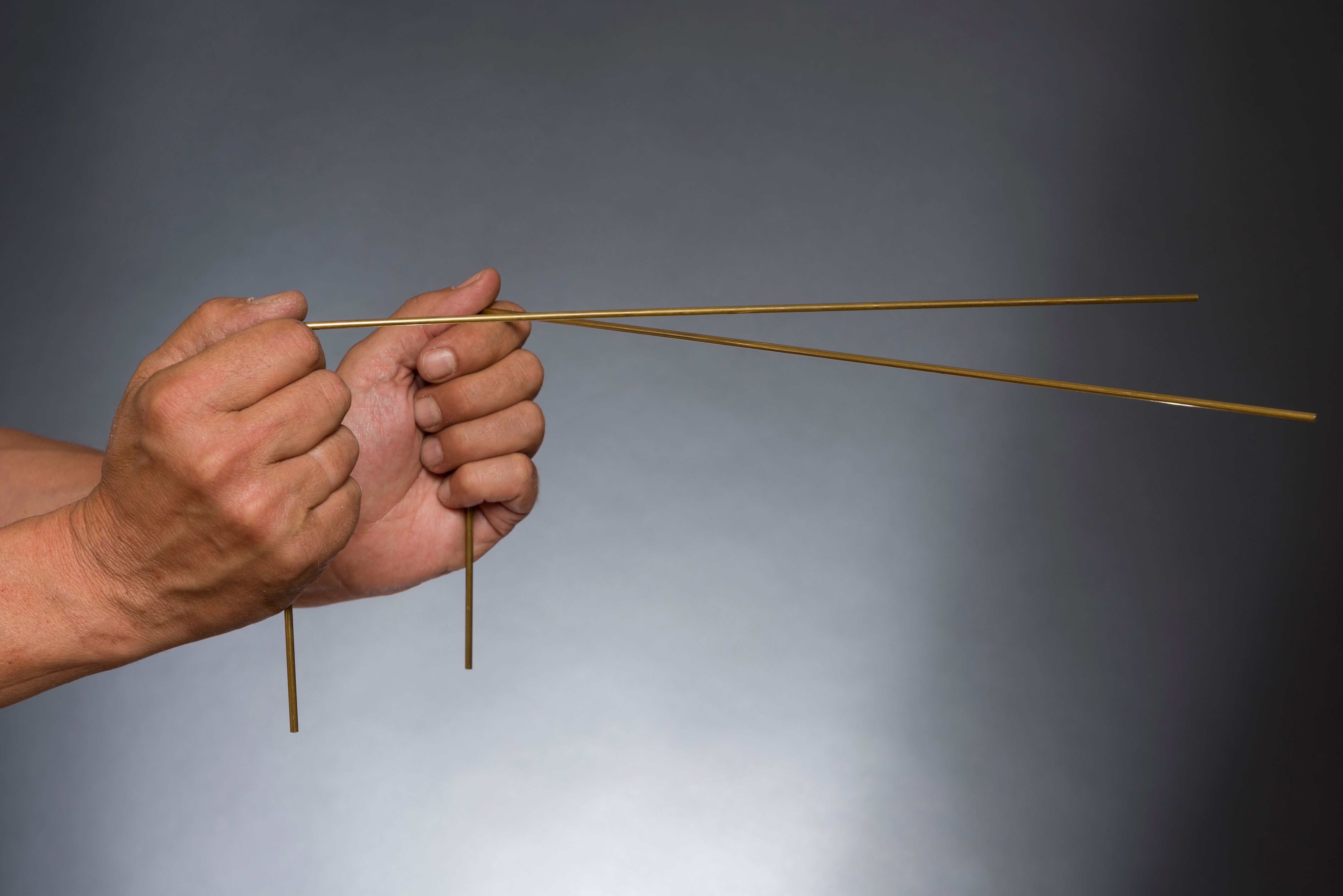 Man holding dowsing rods with both hands Man holding dowsing rods with both hands