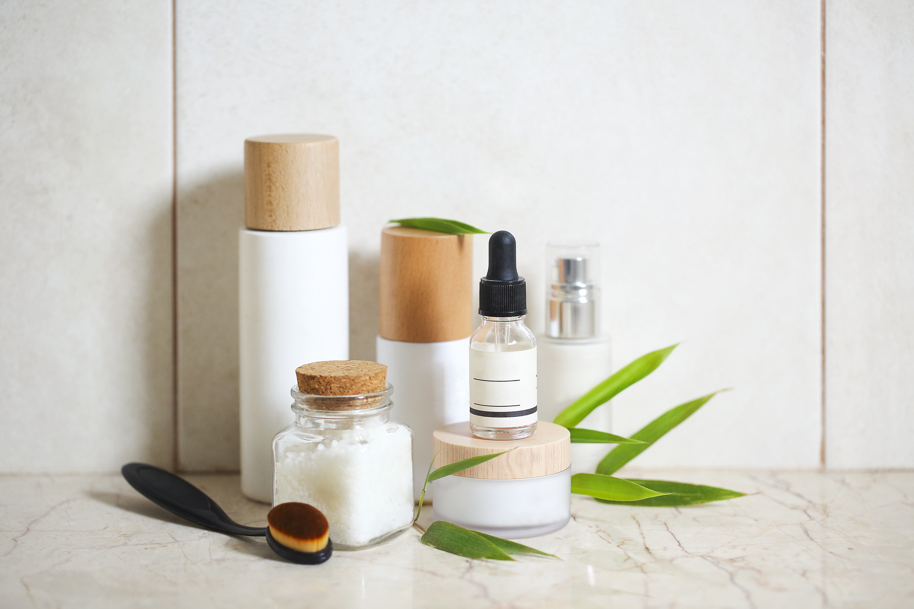 Face cream, serum, lotion, moisturizer and sea salt among bamboo leaves Face cream, serum, lotion, moisturizer and sea salt among bamboo leaves