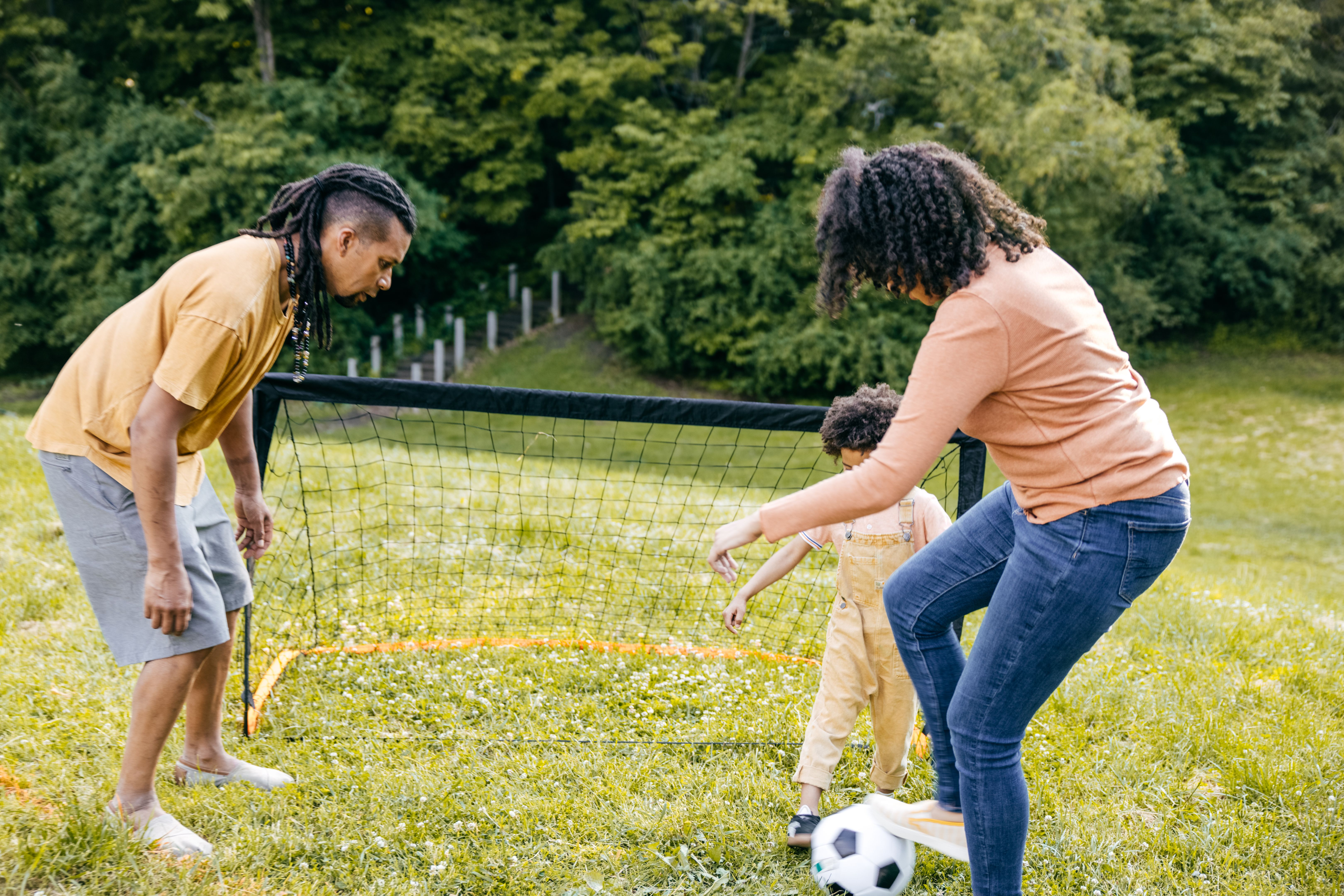 Summertime. Family playing soccer in the park