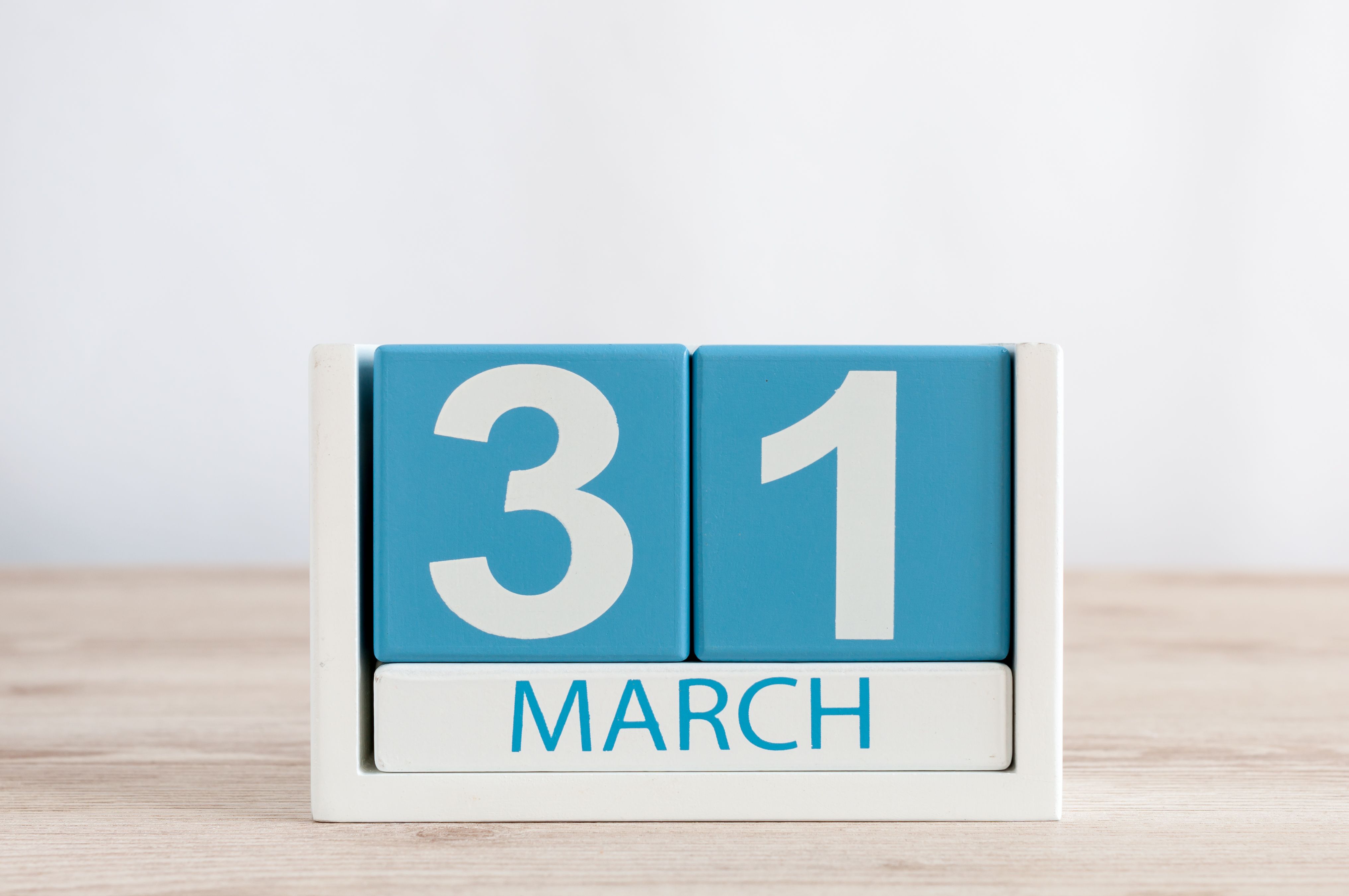 March 31st. Day 31 of month, daily calendar on wooden table background. Spring time, empty space for text