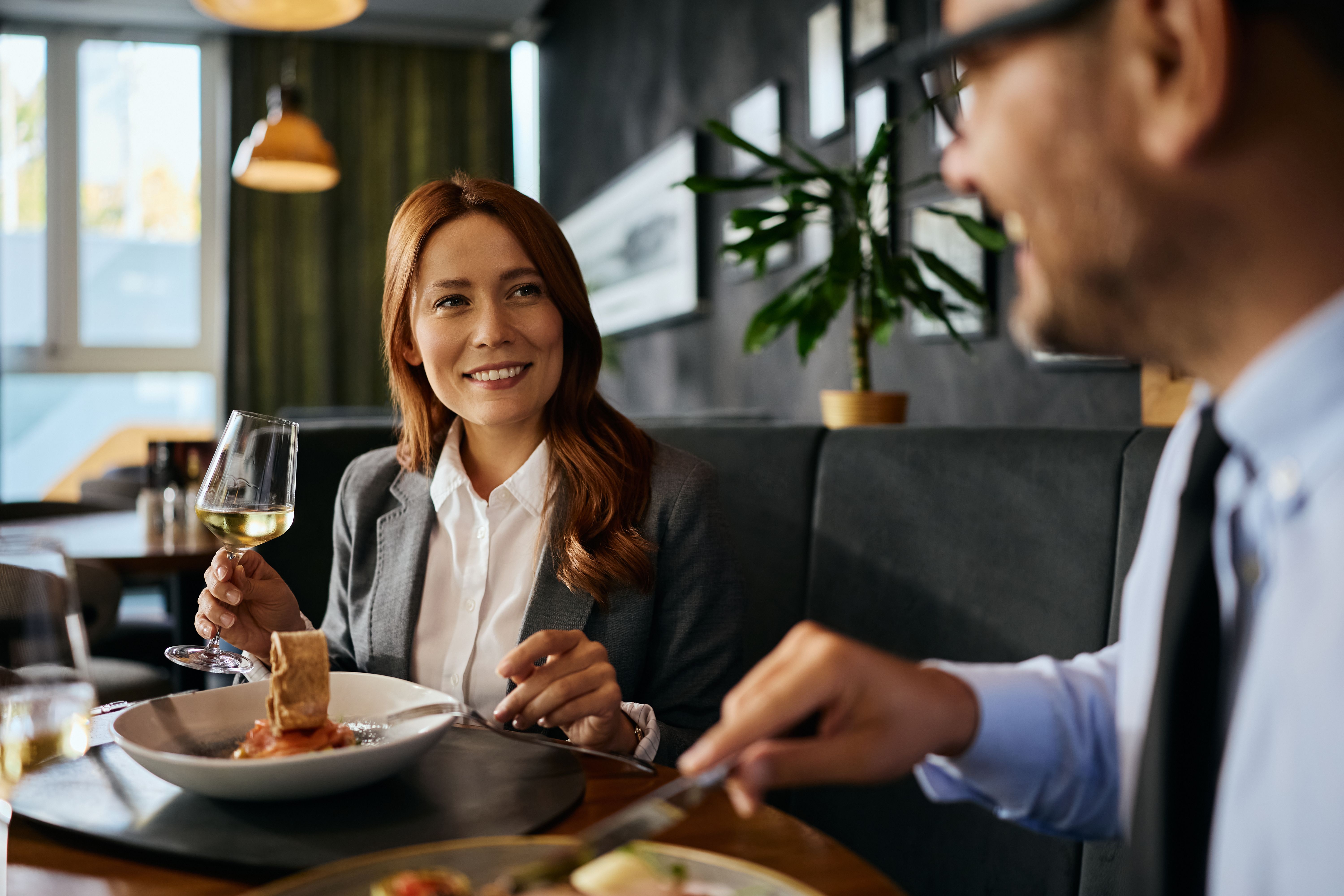Happy businesswoman talking to her colleague during a lunch in restaurant.