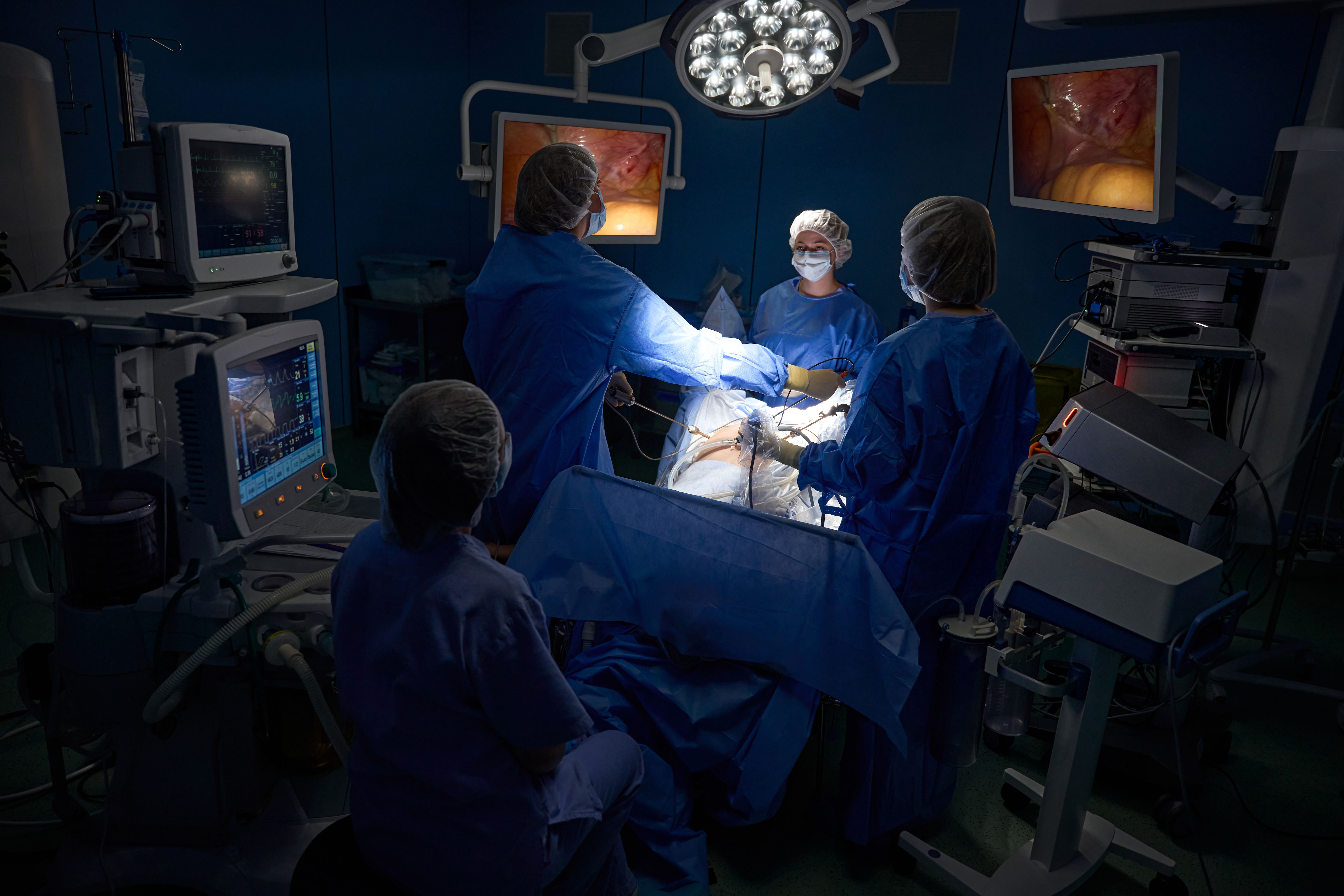Doctors looking at image on monitor during laparoscopic surgery in hospital Doctors looking at image on monitor during laparoscopic surgery in hospital