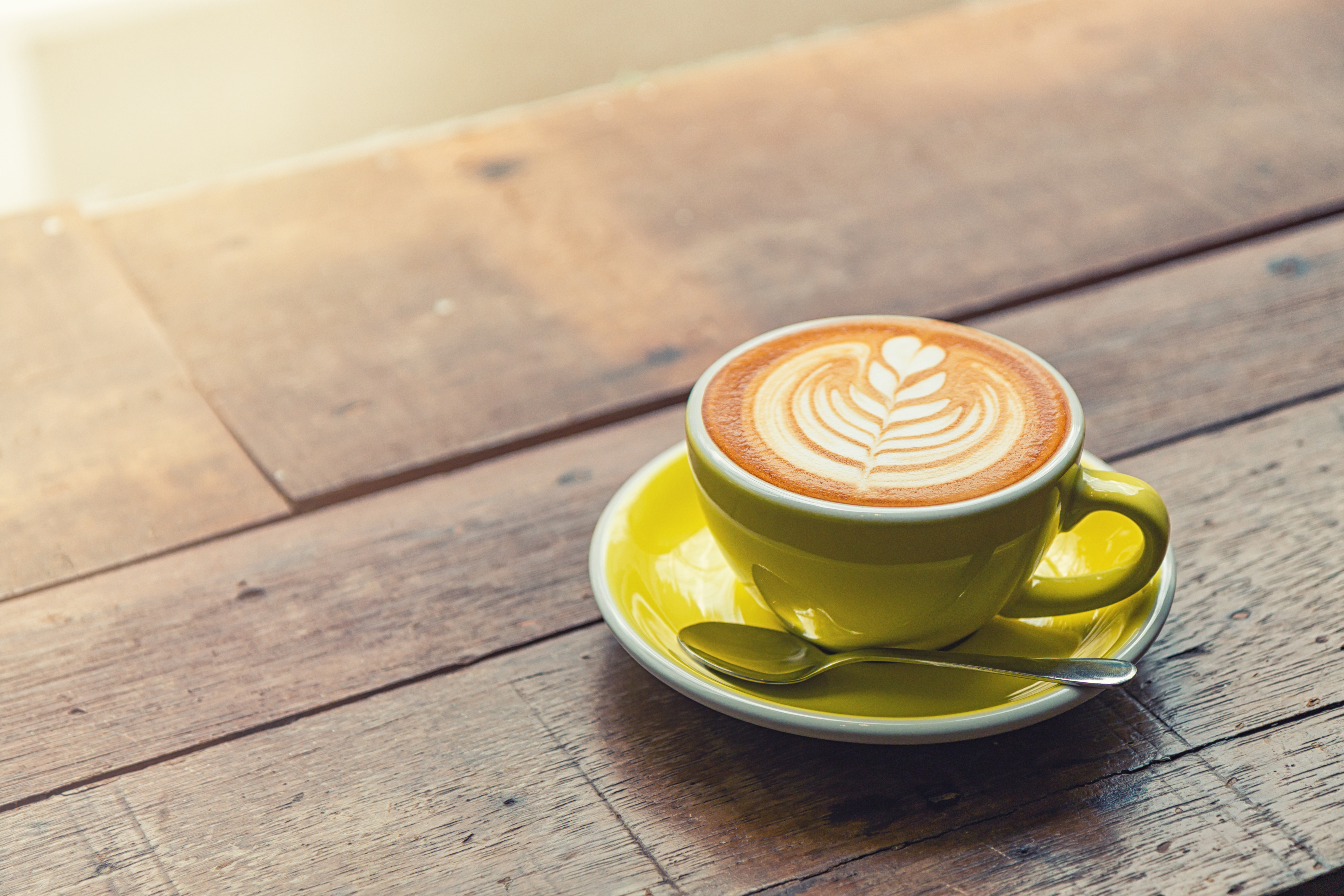 High Angle View Of Coffee Cup On Wooden Table In Cafe High Angle View Of Coffee Cup On Wooden Table In Cafe